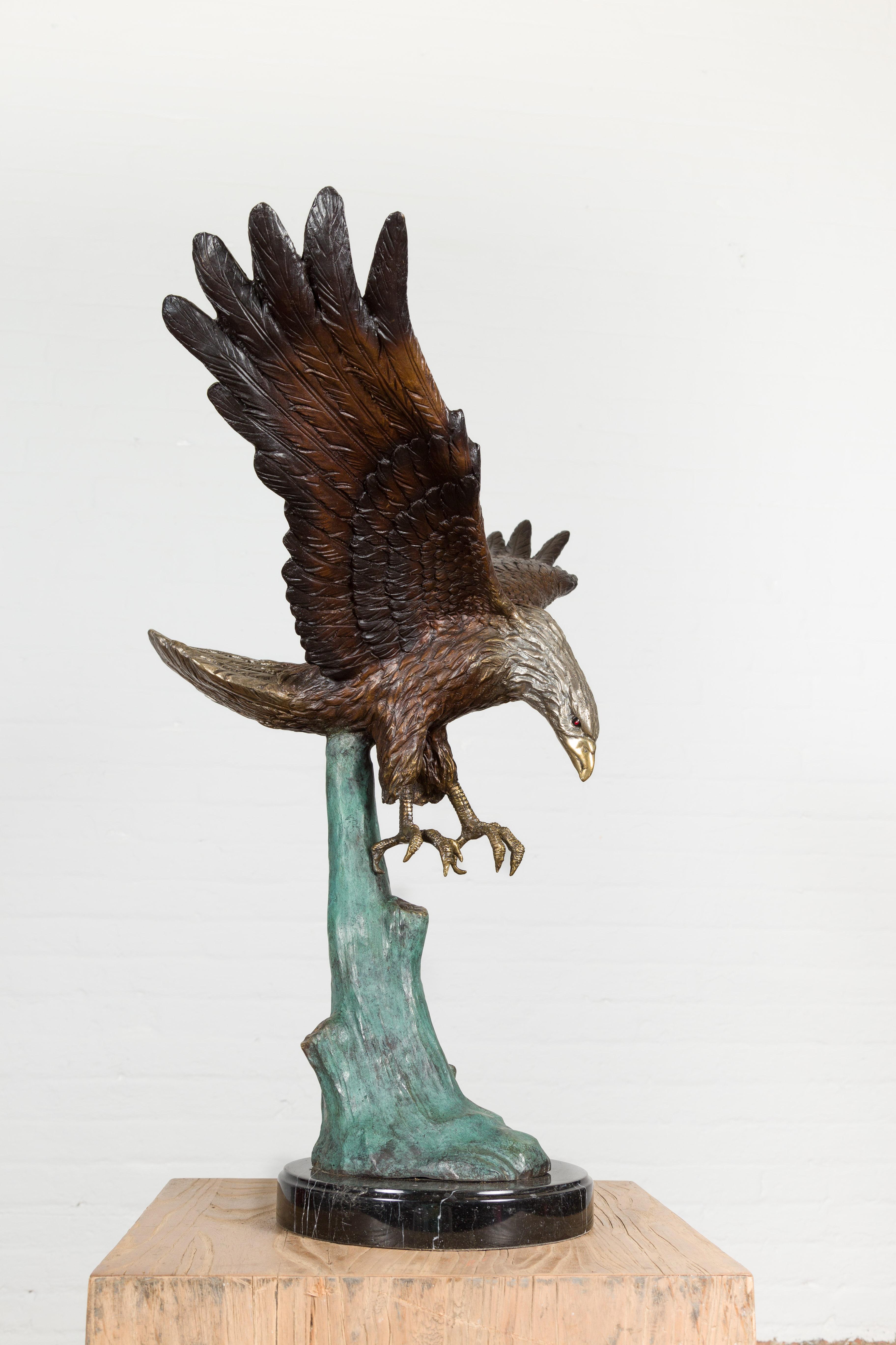 Sculpture en bronze grandeur nature d'un aigle en train de manger sur socle en marbre noir en vente 7