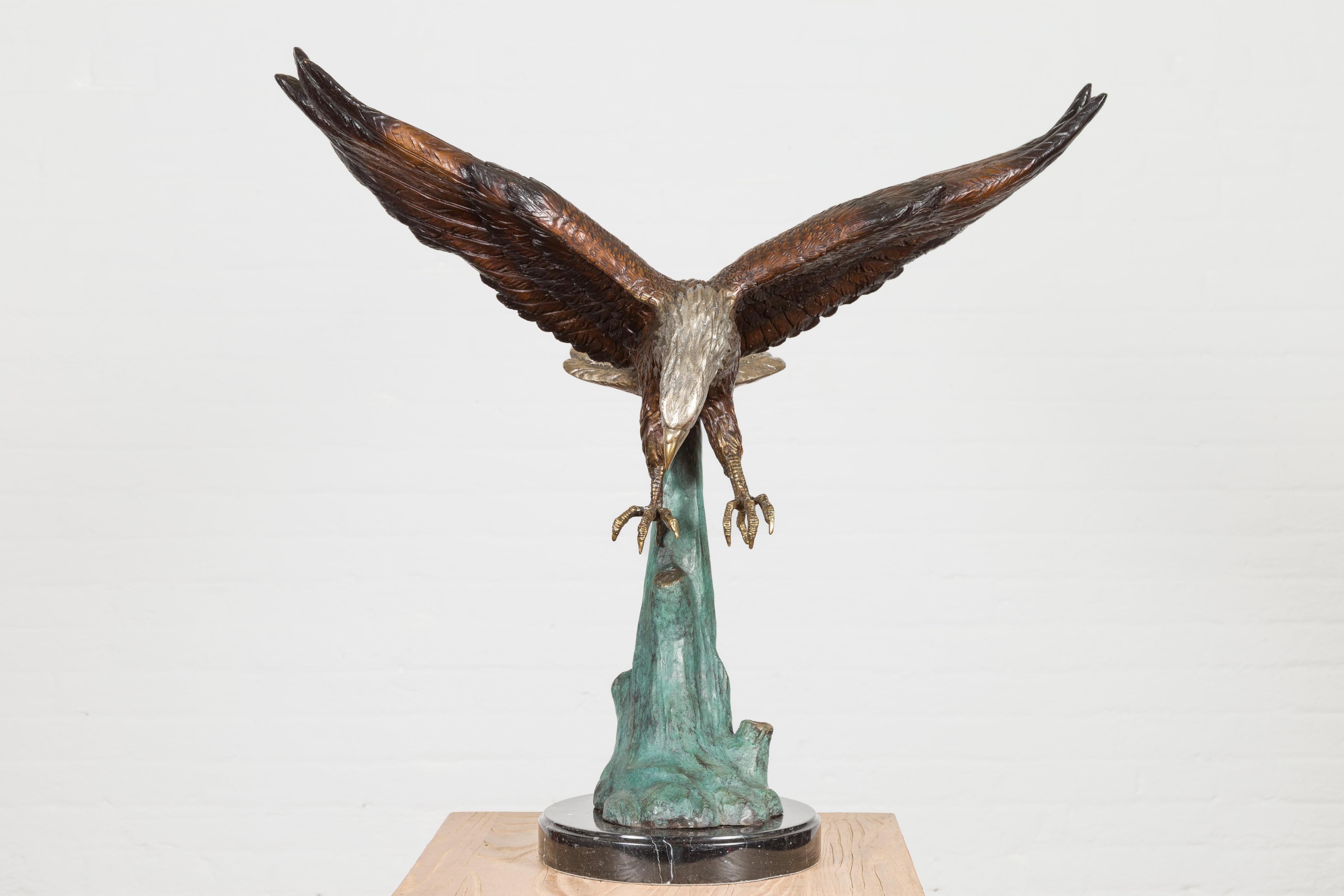 Moulage Sculpture en bronze grandeur nature d'un aigle en train de manger sur socle en marbre noir en vente