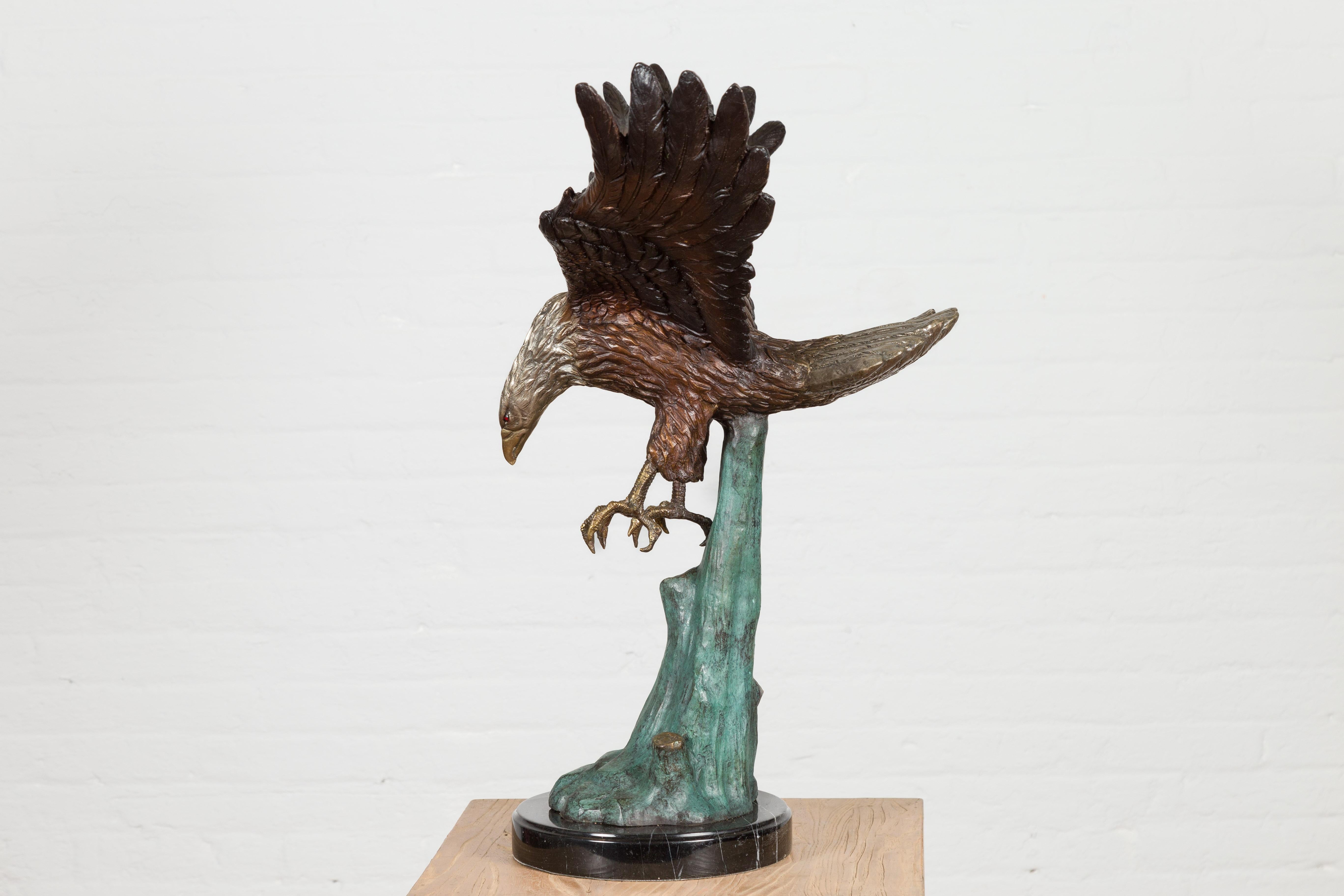 Sculpture en bronze grandeur nature d'un aigle en train de manger sur socle en marbre noir en vente 3