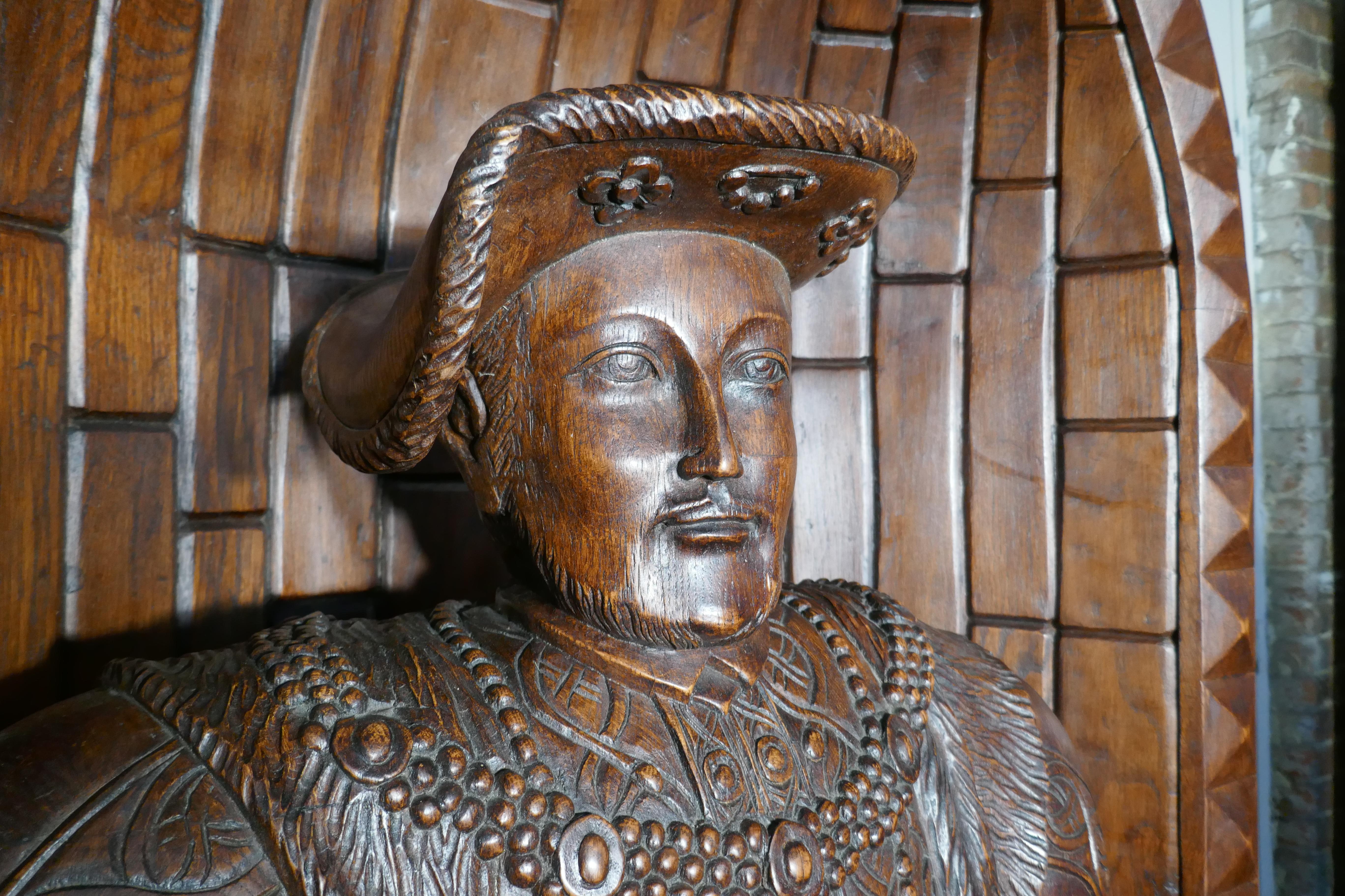 Life size carved oak statue of Henry VIII standing in an 8ft Alcove

This is a mid-20th century piece, it is very impressive and was made for display as part of a theatrical collection of Tudor Clothes
The quality of the carving is extremely fine