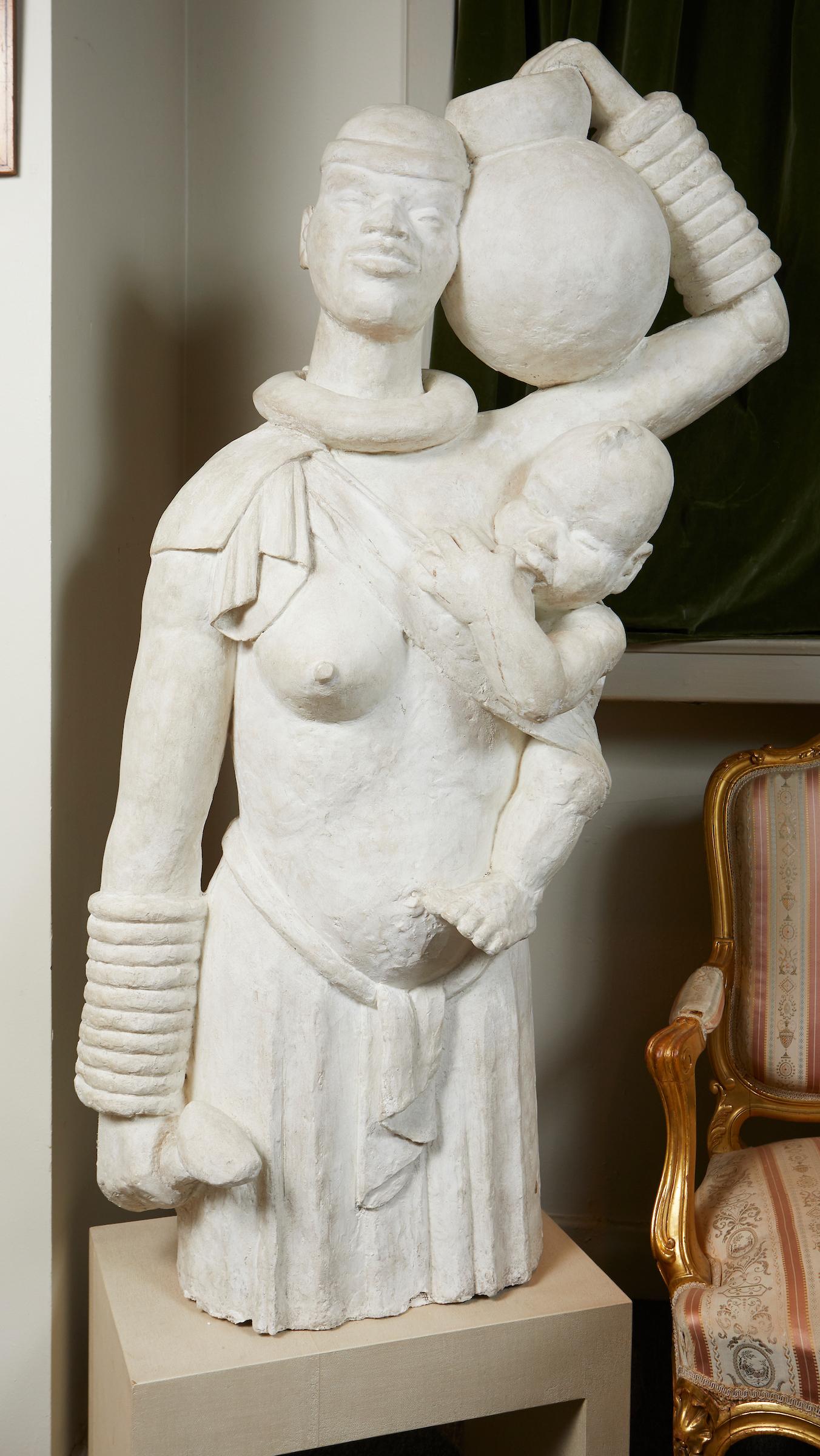 French Africanist style plaster carved sculpture of a mother carrying water and feeding her child.