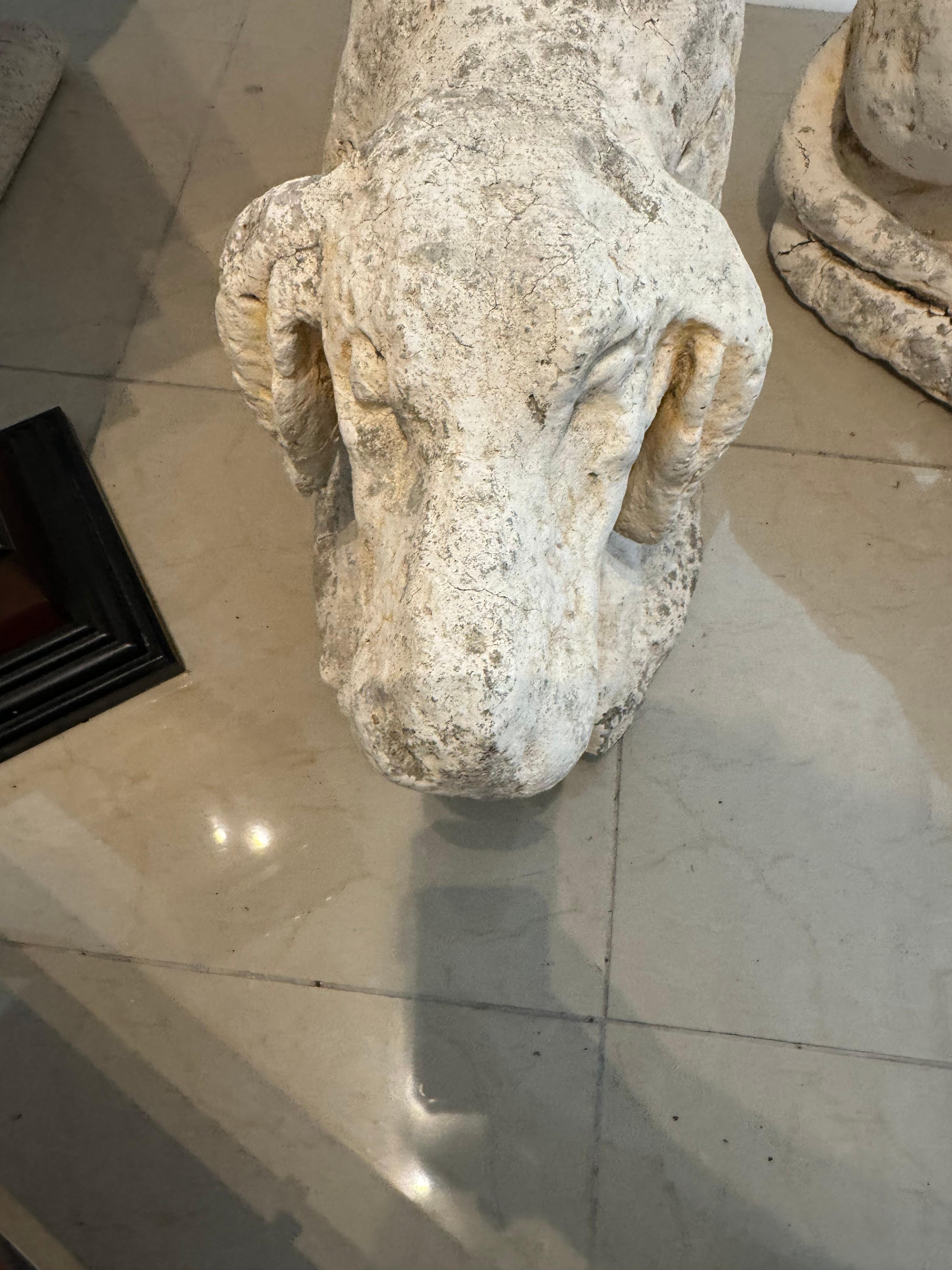 Estas encantadoras esculturas de perro destacan por su pátina única. Esculpidas a mano con hormigón y reforzadas con barras de refuerzo, estas piezas muestran detalles intrincados, como la barra de refuerzo visible en el perro que se rasca la oreja.