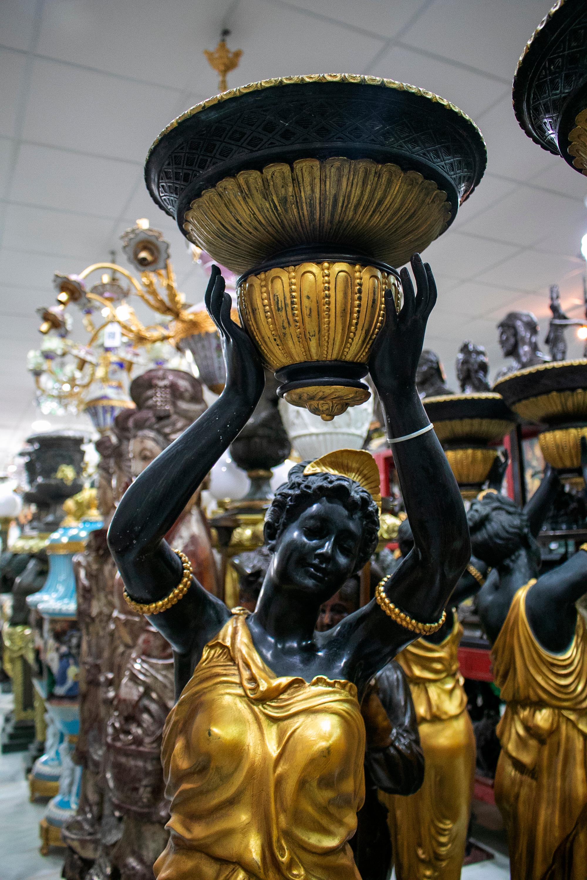 Life-size pair of gilt bronze torcheré female statue standing lamps on white and black marble bases.