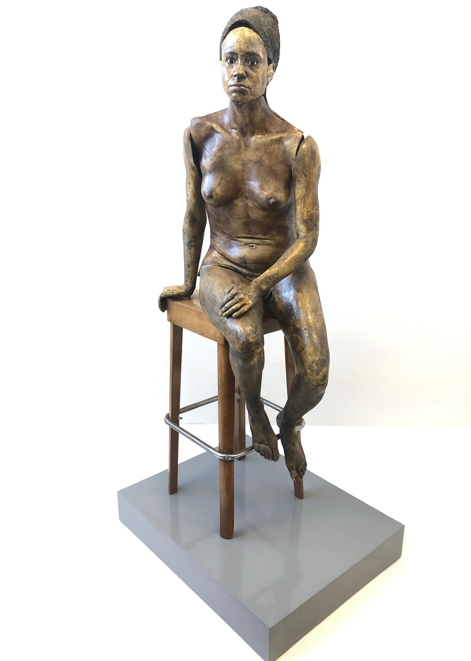 Escultura femenina desnuda en cerámica Raku de tamaño natural de la década de 1980, obra de la escultora estadounidense Eva Stettner.
Construido con cerámica esmaltada al fuego lento, el taburete es de madera lacada con un reposapiés cromado y la