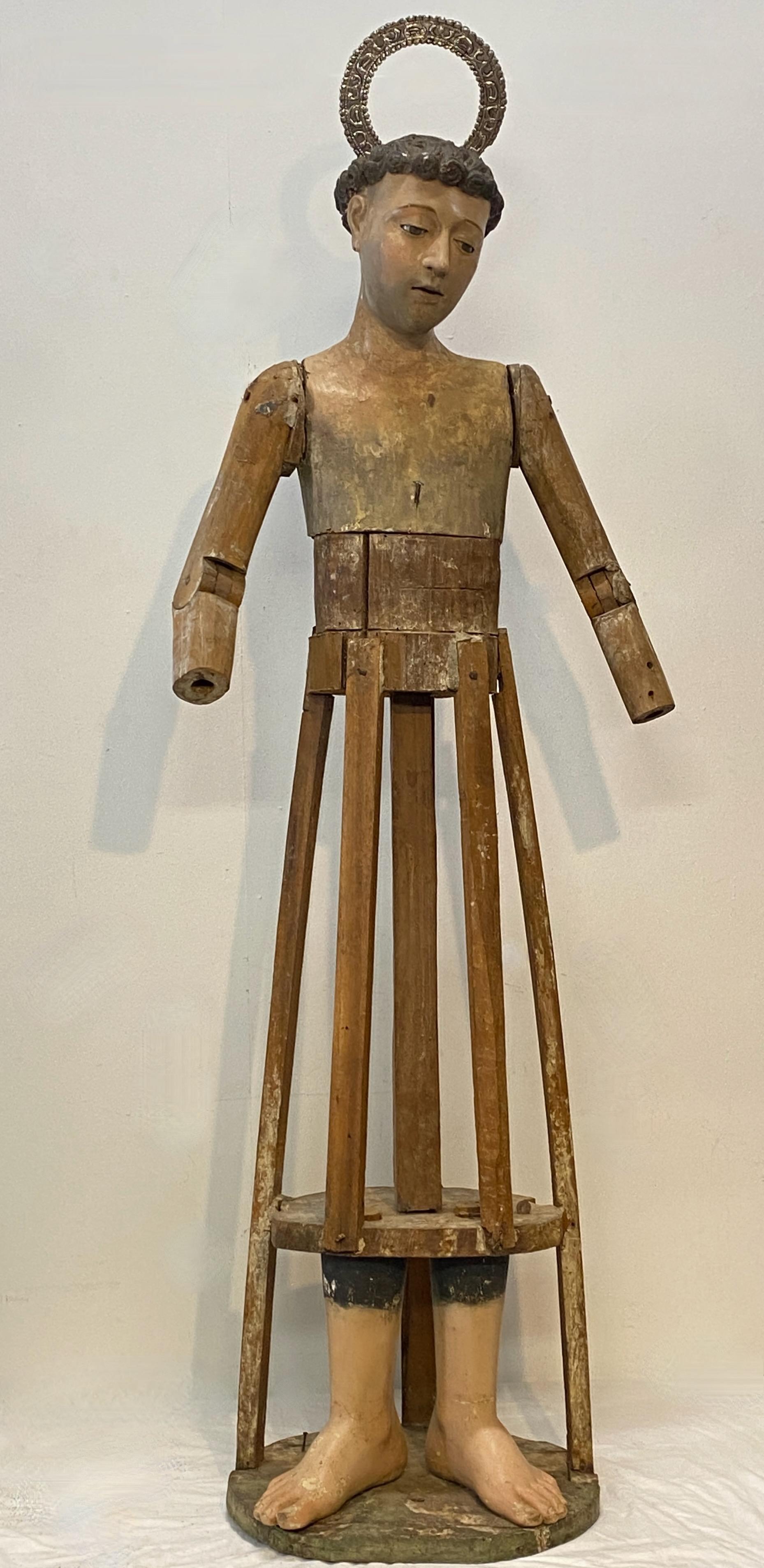 A life-size Spanish religious Santo of St Francis in carved and polychromed wood. Hand painted features with glass eyes and silver halo or crown. He would have been appropriately clothed in its day. 
Expected signs of age with some losses, bust