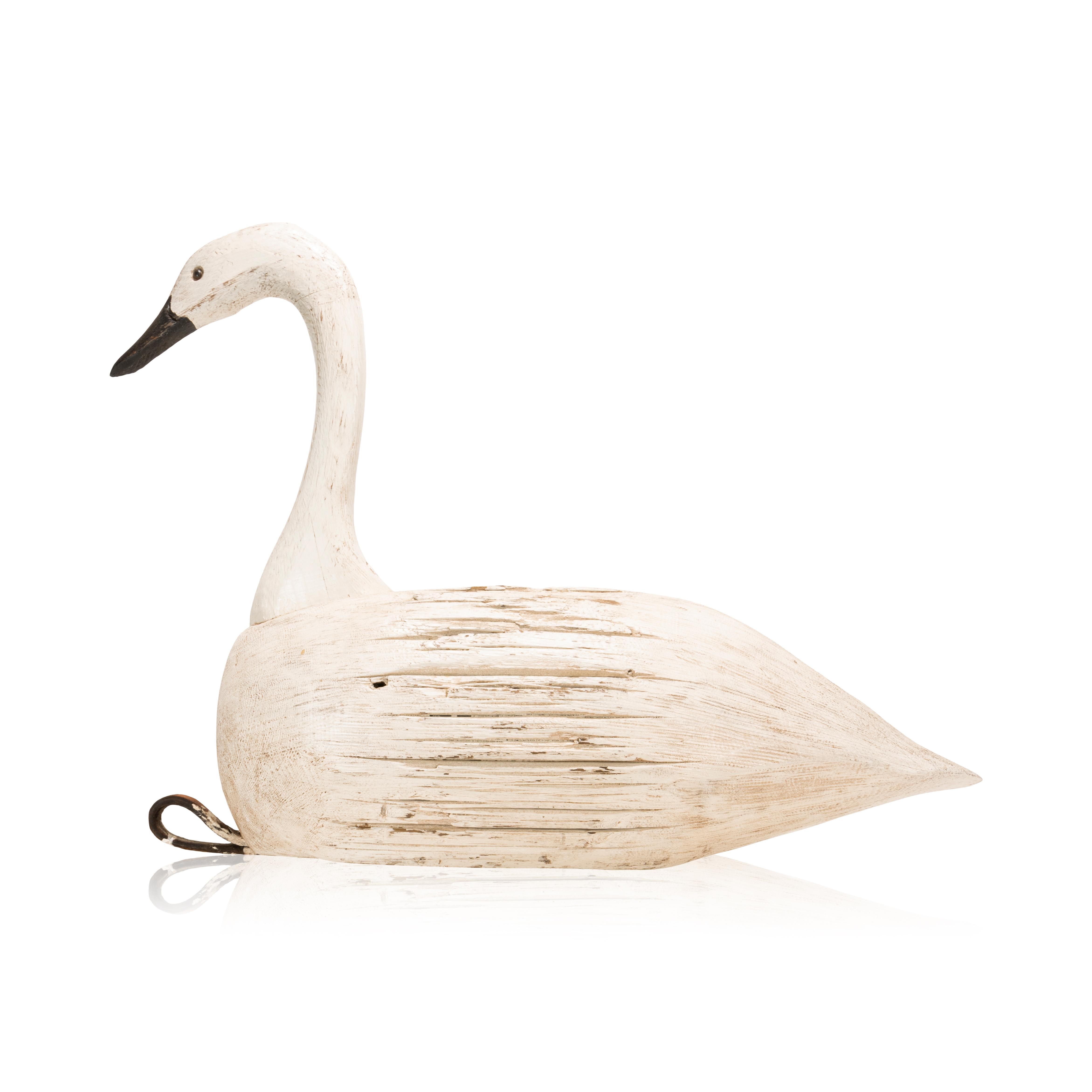 Decorative swan decoy carved from a barn beam. Glass eyes, original paint. Carver unknown. Original cream white paint.

Period: Mid-20th century
Origin: United States
Size: 25