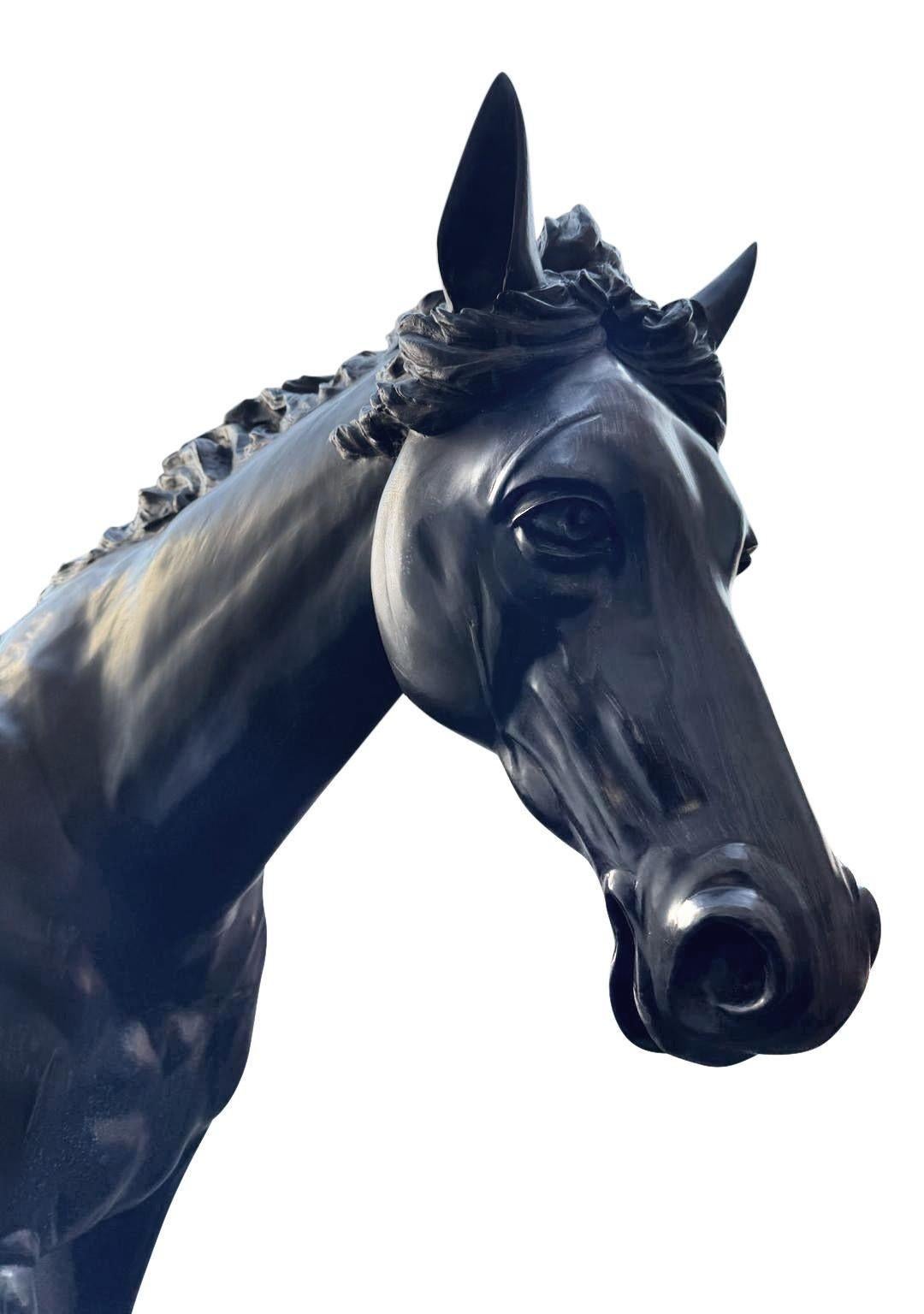Diese lebensgroße Bronzestatue eines Hengstes aus dem frühen 20. Jahrhundert verkörpert sowohl Kraft als auch Eleganz. Die aufwändigen Details fangen die kraftvolle Muskulatur und die dynamische Haltung des Pferdes ein und zeigen eine wallende Mähne