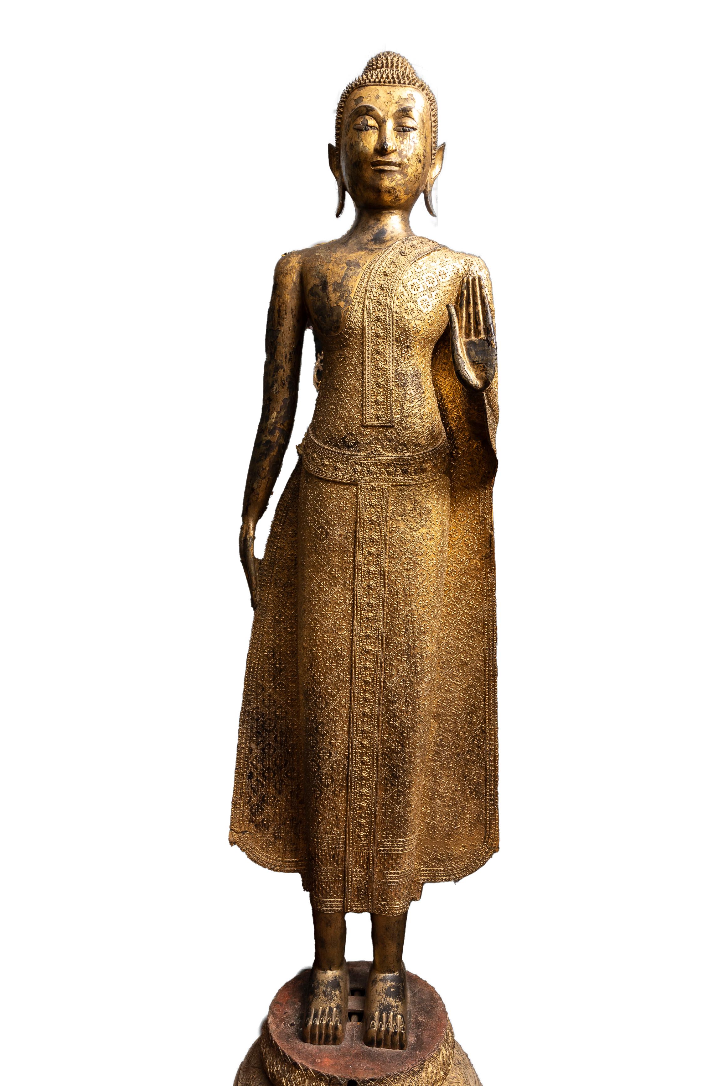 A Life-Size 19th Century Gilt Bronze Thai Buddha with Mother of Pearl Eyes.  This life-size Thai gilt bronze Buddha stands serenely in the Abhaya Mudra, a gesture symbolizing fearlessness and protection. The figure reflects the influence of the