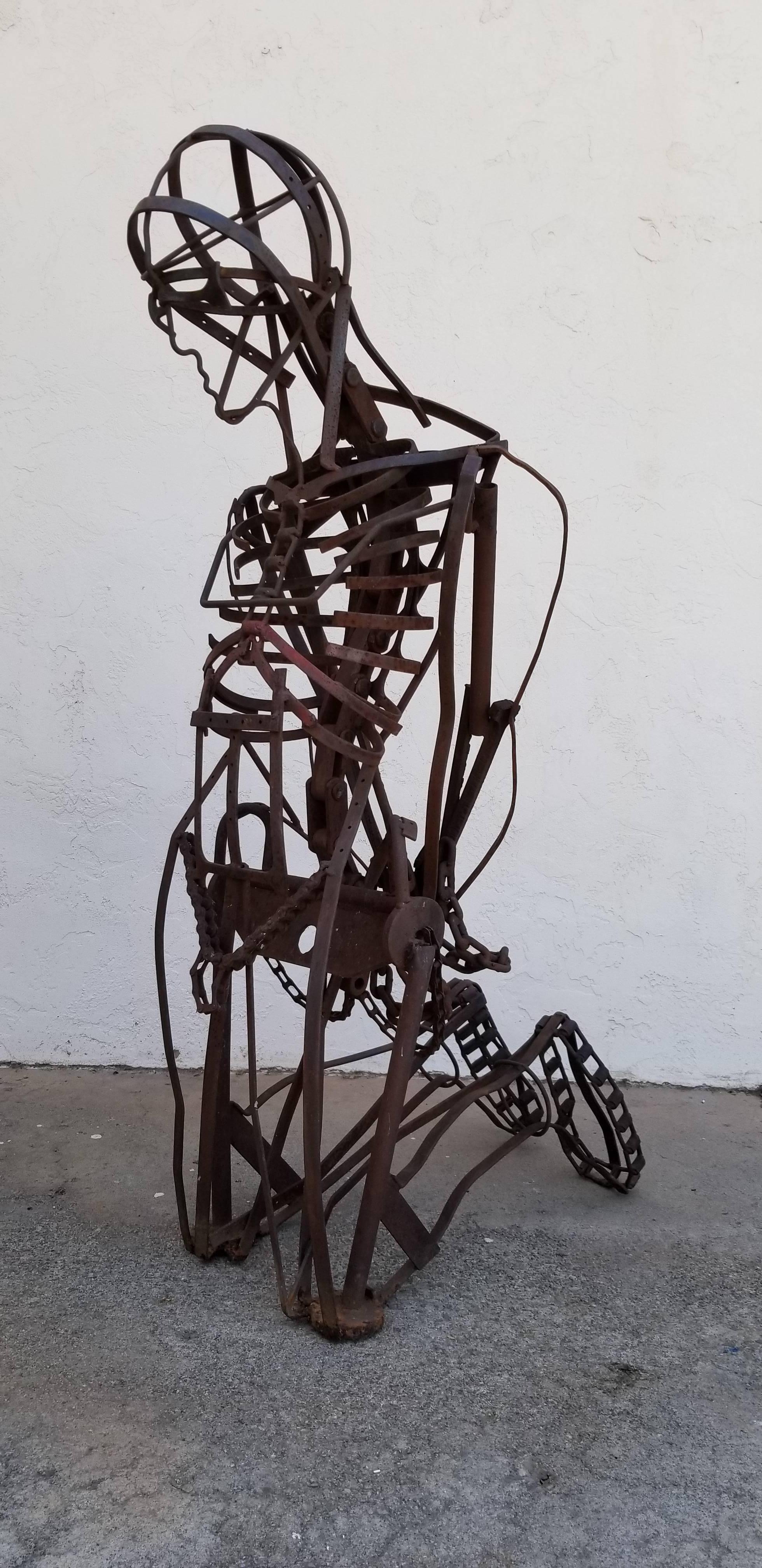 Exceptional large-scale, abstract human figure in bondage, assemblage iron and steel sculpture. Skilfully detailed kneeling figure created from various iron and steel parts welded to form. Unique example of the Industrial / Brutalist / Assemblage