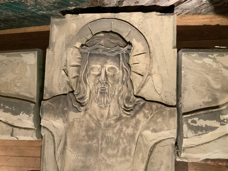 A mid-20th century life sized architectural carved figure of the crucified Christ, carved from NY sandstone from Medina NY. The figure of Christ carved into the face of the stone blocks, with the body in one sections and each arm in a separate block