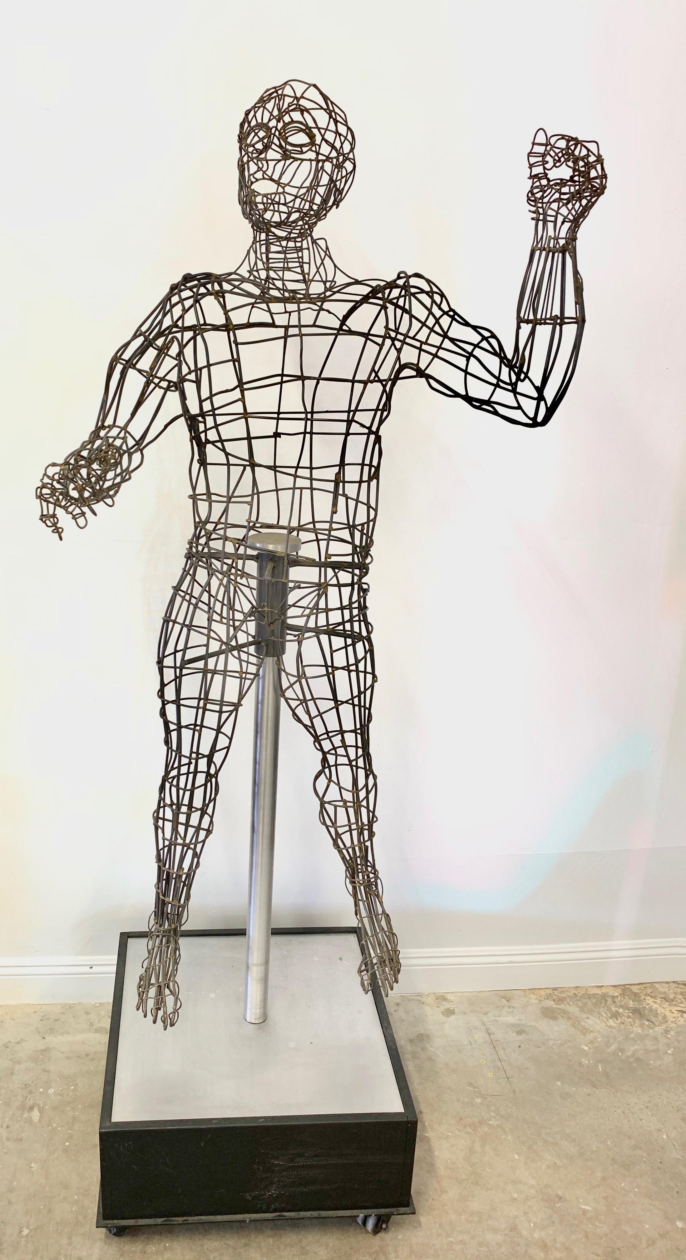 Massive wire sculpture of a man by Bruce Gray. Life-sized sculpture floating on rolling cube base. Measures: Just over 7 feet tall. Fantastic detail and presence. Excellent condition.