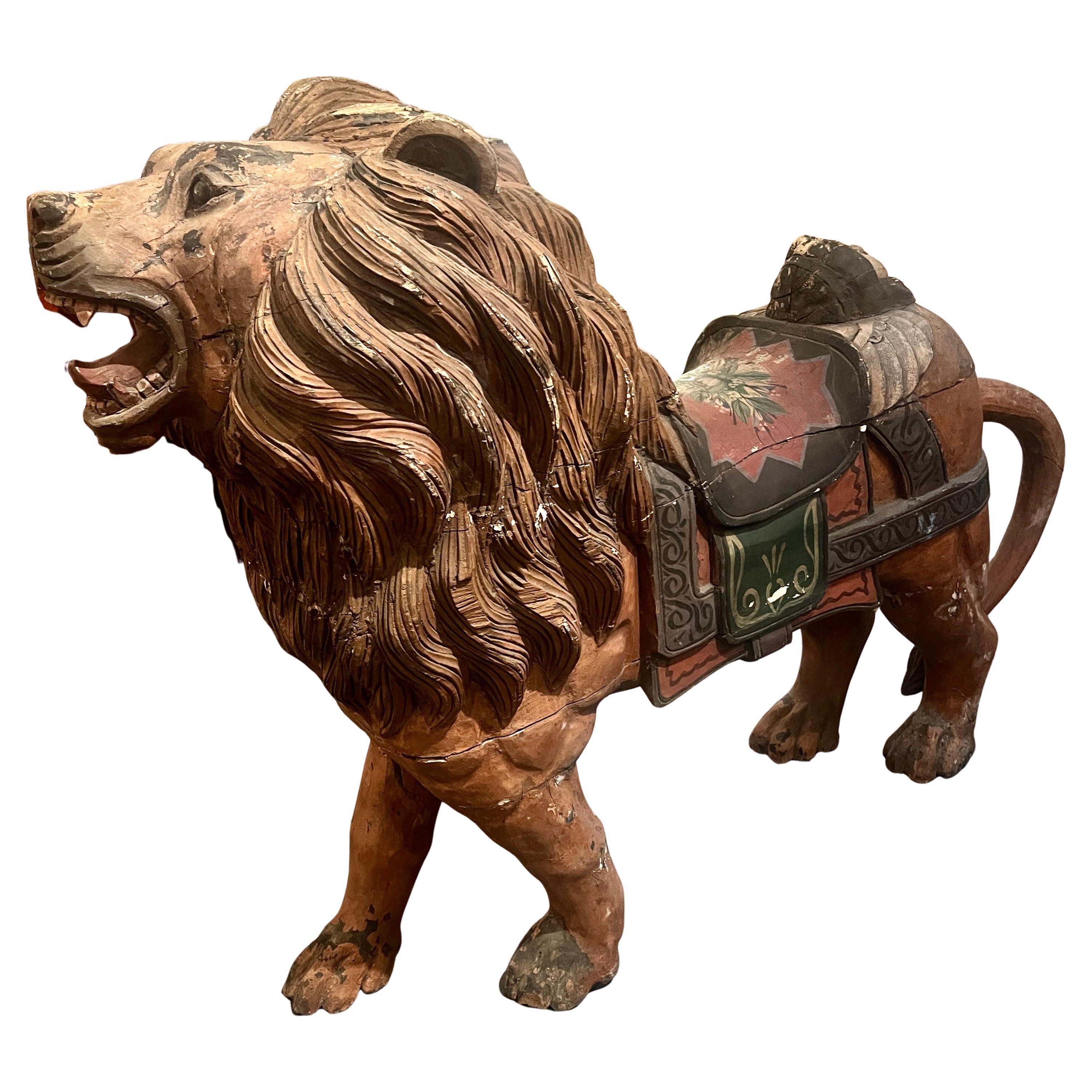 Un león de carrusel de época tallado a mano, muy regio y majestuoso.  Todo hecho y pintado a mano, con gran detalle en el trabajo de la madera y la montura pintada y la cabeza de mujer (o querubín) tallada en la parte trasera.  

Una pieza muy