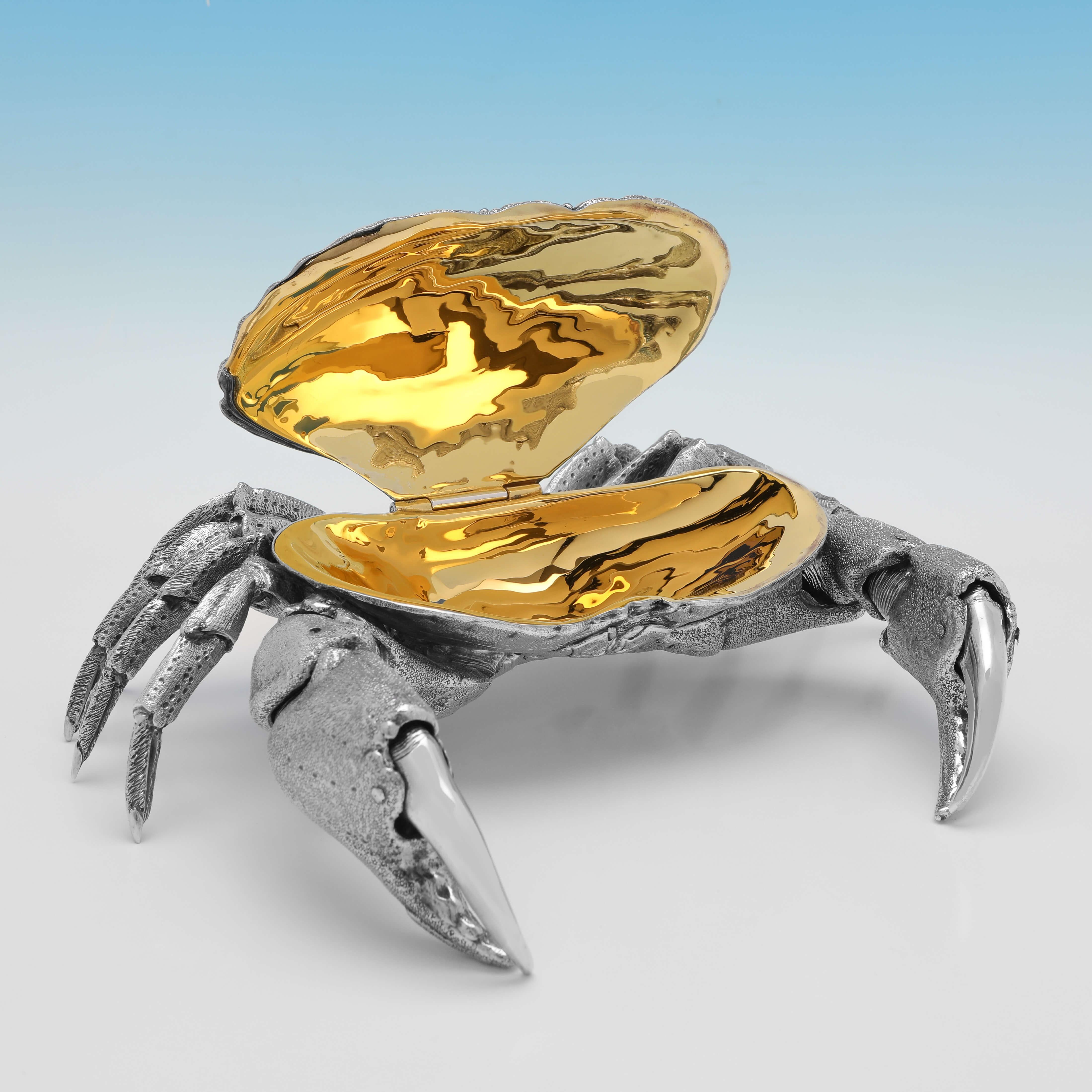 Hallmarked in London in 2007 by William Comyns, this stunning and very realistic, sterling silver model of a crab, has a hinged shell with a gilt interior to be used to serve crab meat, and also features very lifelike movable pincers. 

The crab