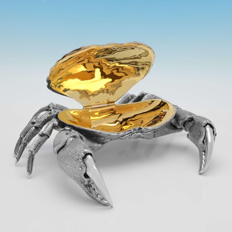 Hallmarked in London in 2007 by William Comyns, this stunning and very realistic, sterling silver model of a crab, has a hinged shell with a gilt interior to be used to serve crab meat, and also features very lifelike movable pincers. 

The crab