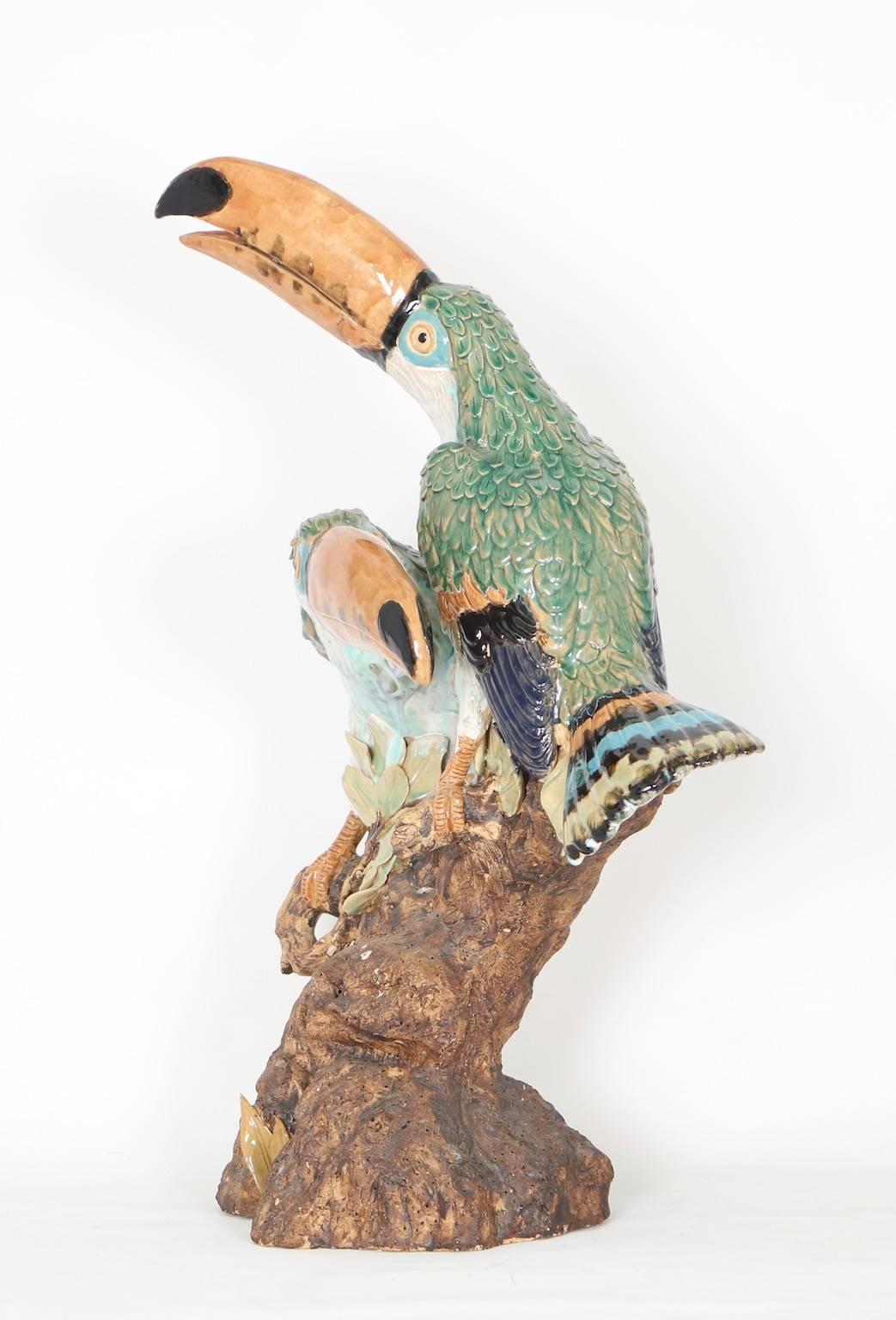 Two life-sized toucans depicted perching on a tree branch in this Italian majolica sculpture. This piece is in the style of Minton naturalistic fauna that was created in the late 19th century.

This item is in excellent vintage condition and has