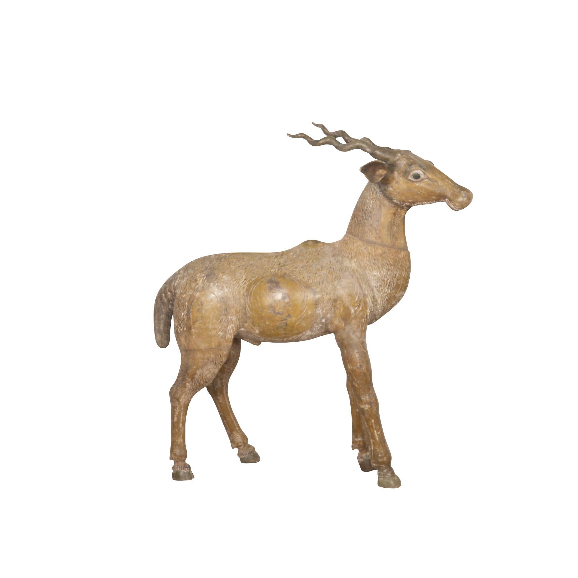  Eine ungewöhnliche holzgeschnitzte Antilope aus dem späten 19. Jahrhundert, mit naivem Gesichtsausdruck und in gespreizter Haltung, fertiggestellt in seiner originalen, farbenfrohen Dekoration. Um 1880.

H: 91 cm (35 13/16