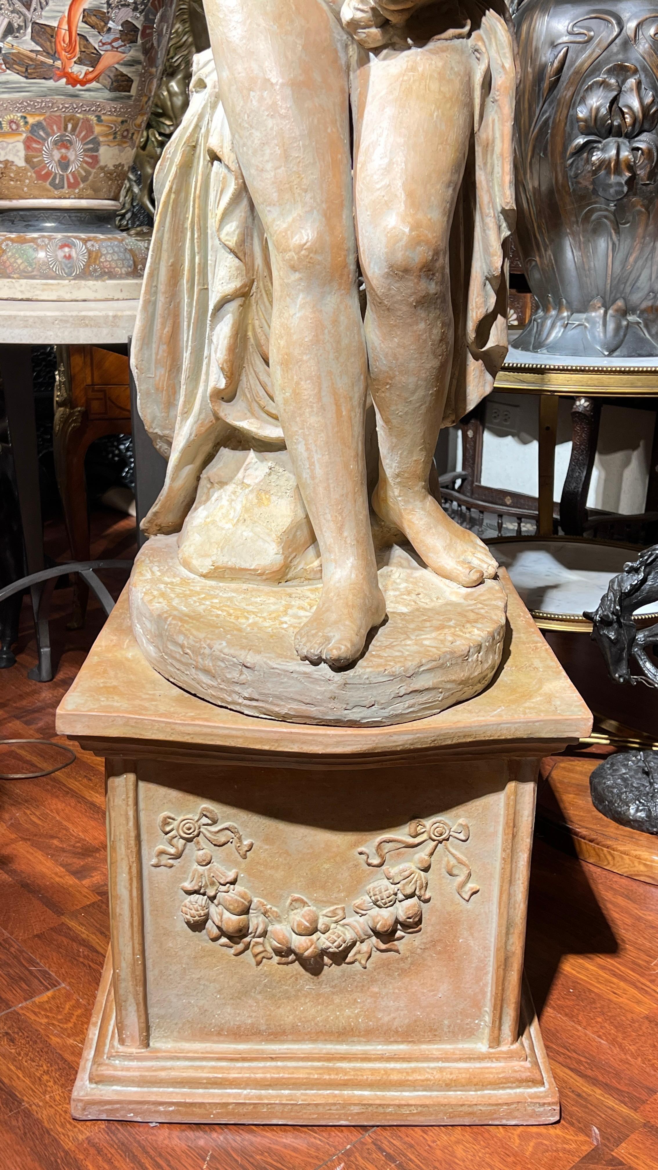 Lovely lifesize terracotta figure of Venus in her bath set upon a rectangular pedestal.