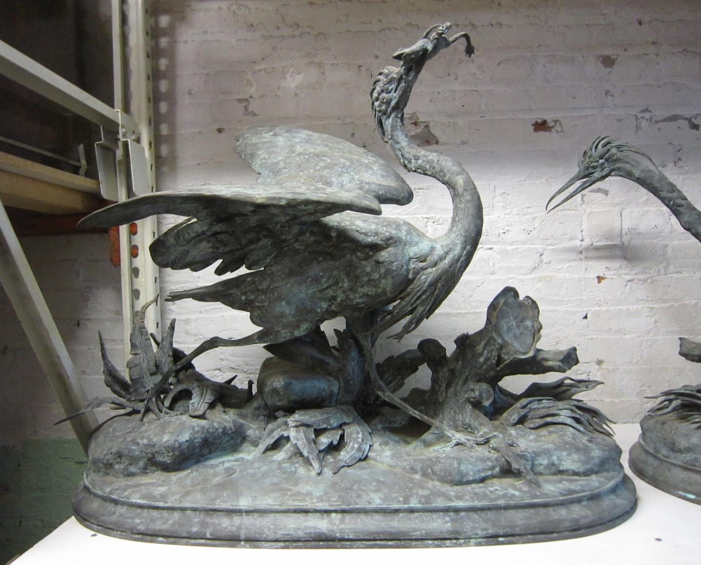 This important and unusual pair of life size French 19th century Blue Herons are realistically depicted with the two birds foraging in their natural environment. One large Heron is holding a frog in its mouth, while the other with wings flared and