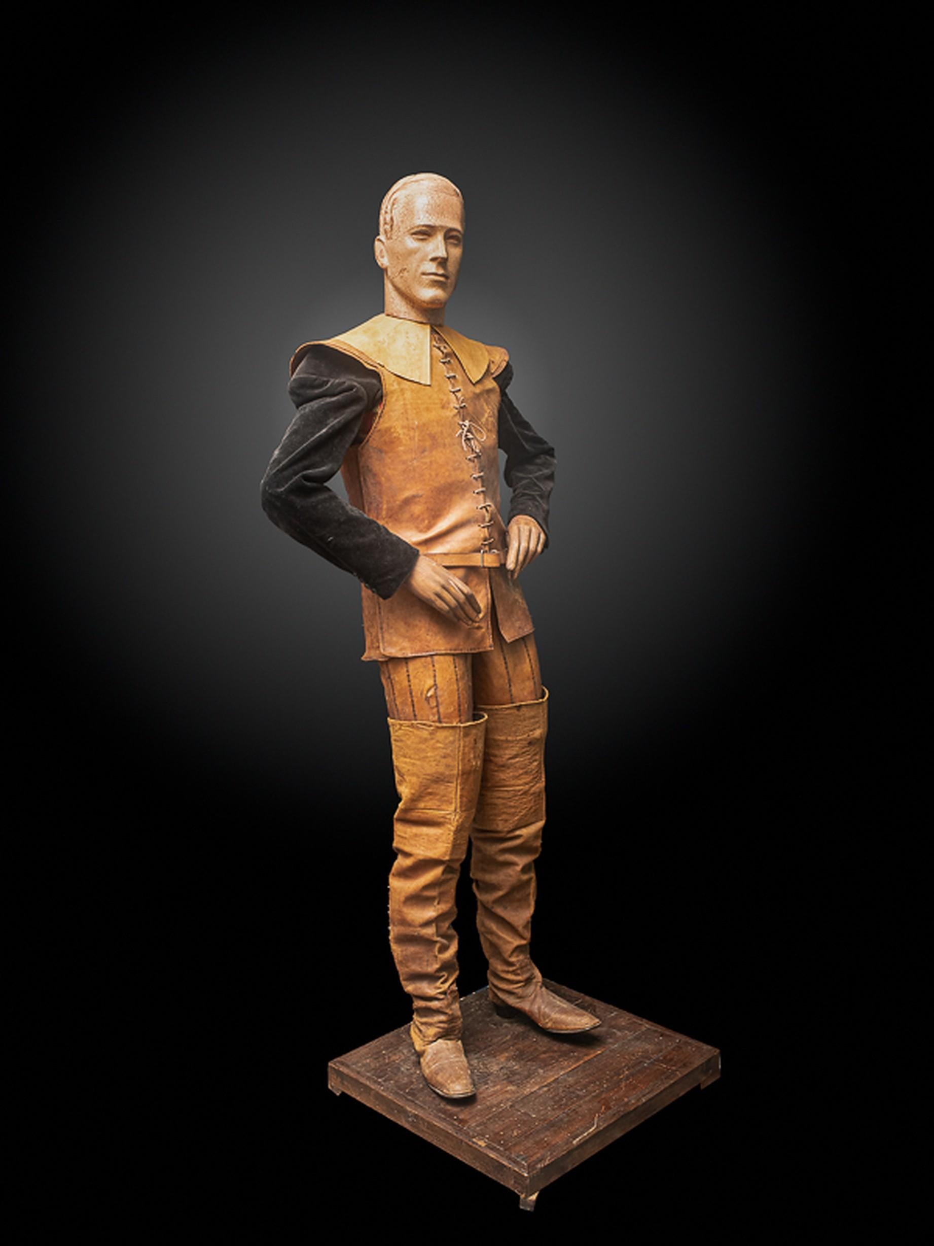 The mannequin is fully dressed in a leather jacket, trousers, boots and a velvet shirt. It is detachable from its wooden pedestal.