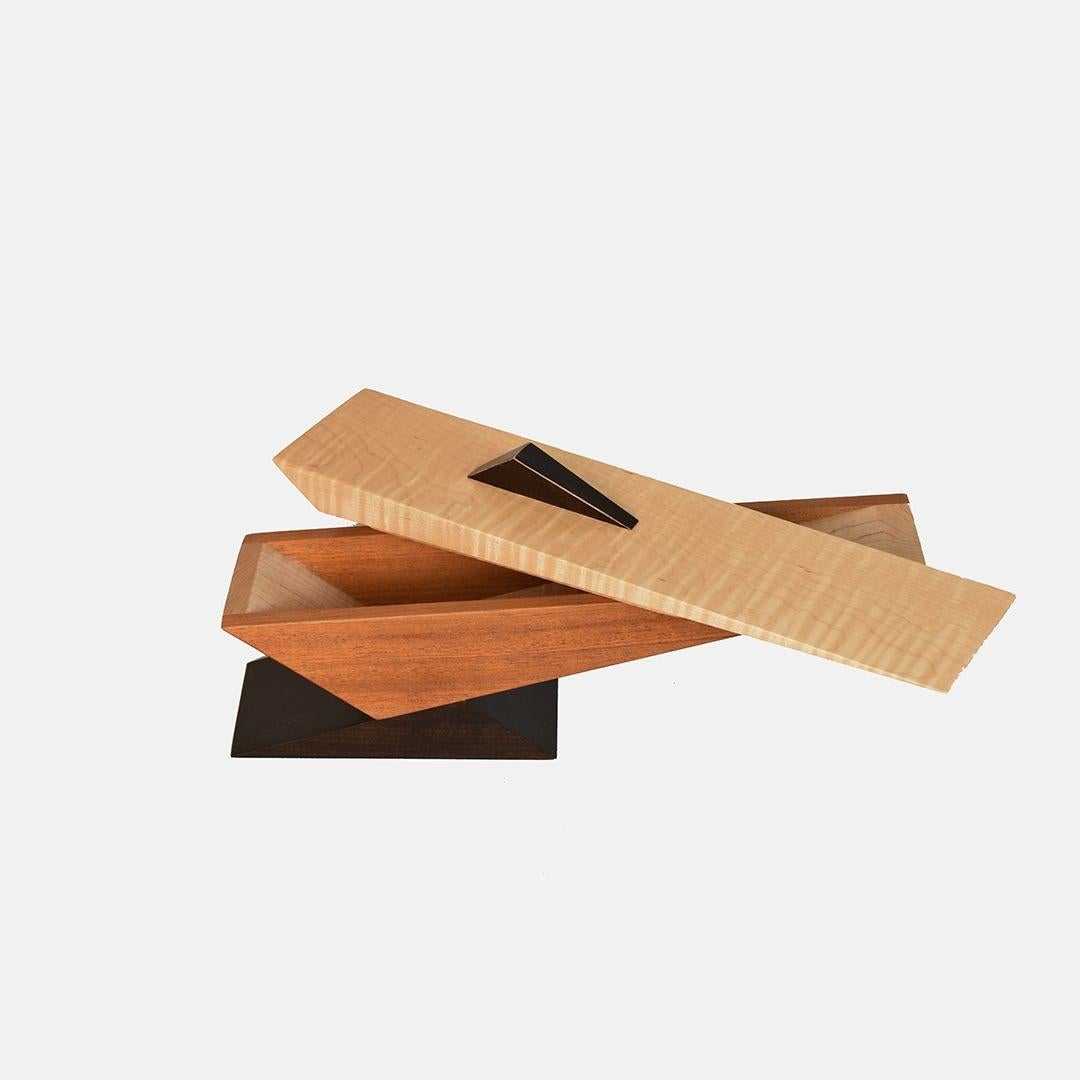 Lee Weitzman, Chicago's renowned custom furniture designer has created modern sculptural vessels from wood. The piece has a discreet lid with space inside which acts as a small storage compartment. 
Materials: natural Sapele with curly maple and