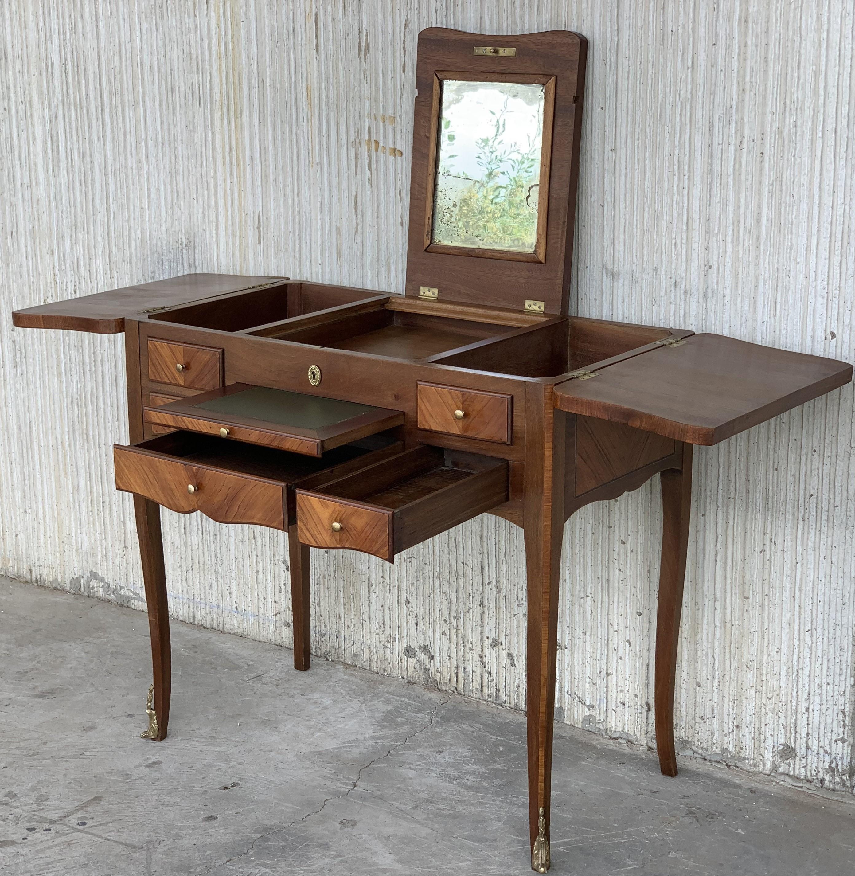 A Louis XVI marquetry dressing table or 'perruquiere', the rectangular top divided into three framed parquetry panels, the outer two hingeing outwards to reveal box sections, while the central section reveals an adjustable mirror. The front with
