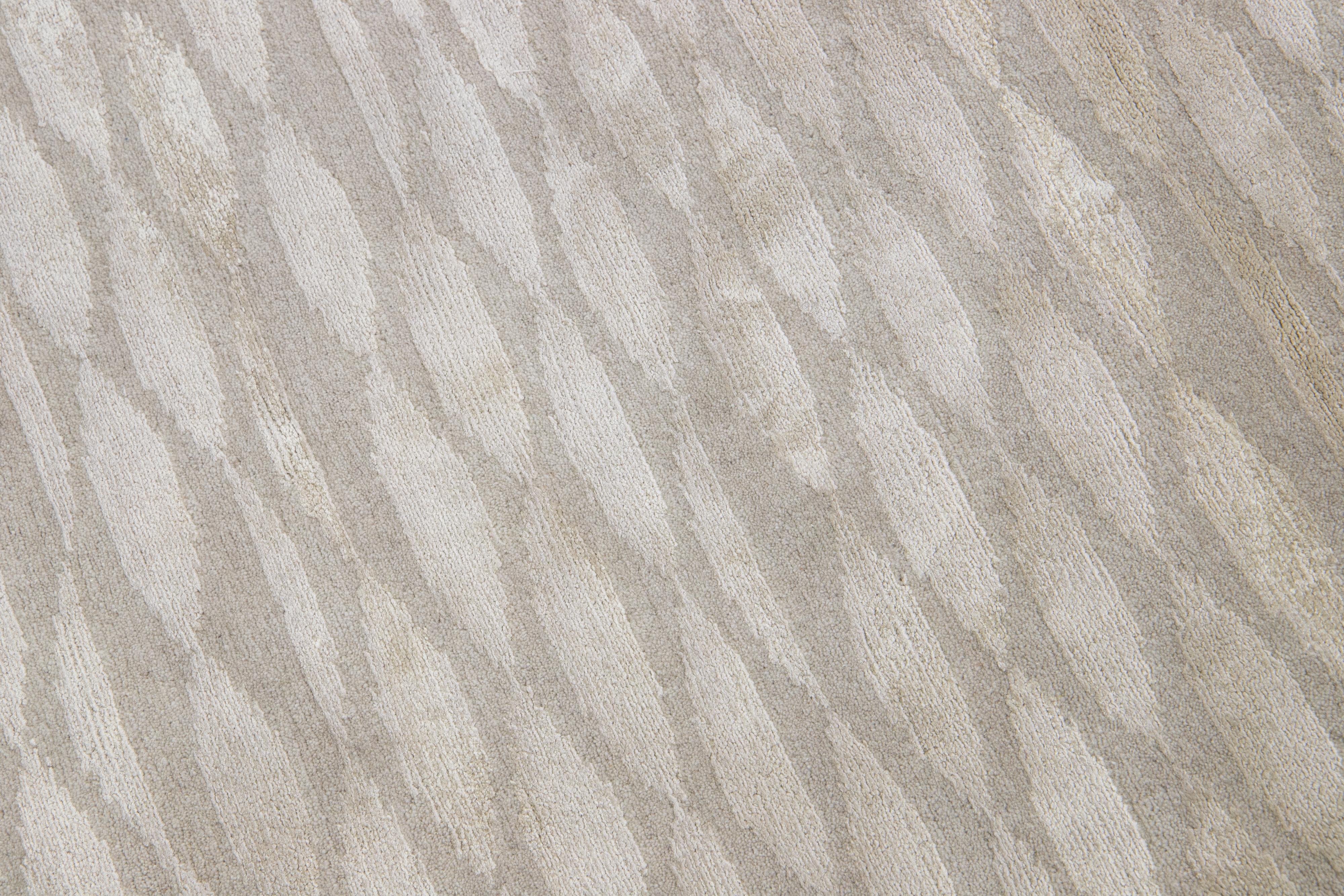 Questo moderno tappeto personalizzato, Tempo, infonde a qualsiasi ambiente lusso, movimento e lucentezza. È annodato a mano con la migliore lana e seta dell'Himalaya e presenta un elegante beige chiaro con una sobria tonalità di blu.

Il prezzo si