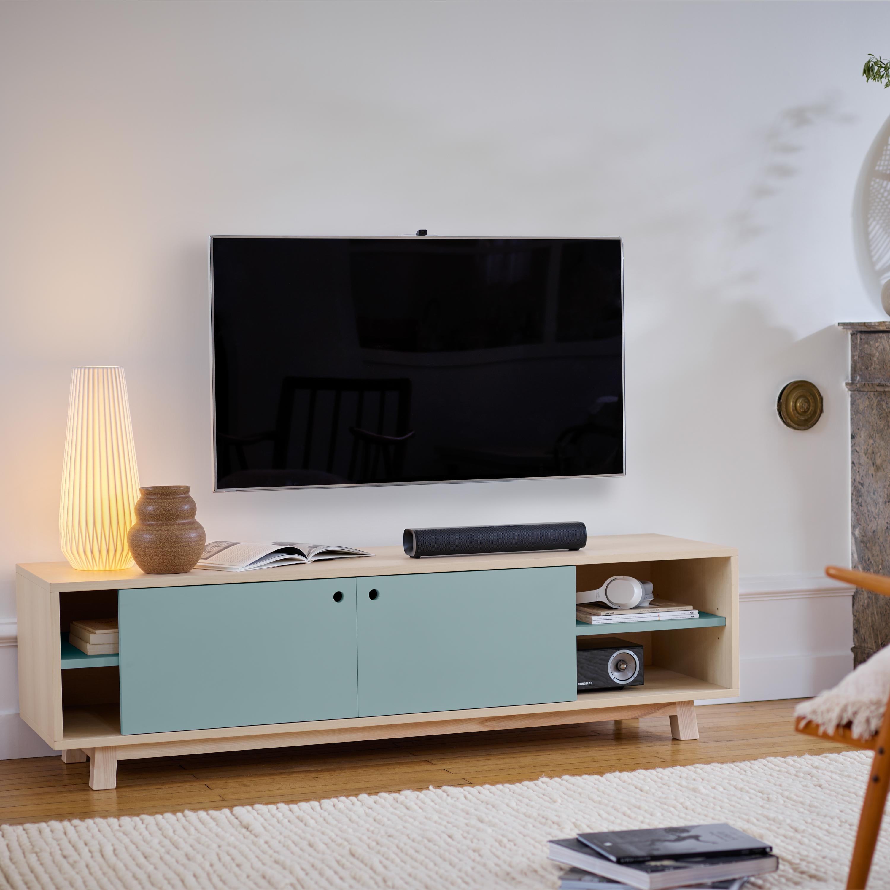 Ce meuble TV avec 2 portes coulissantes est conçu par Eric Gizard - Paris.

Il est 100% fabriqué en France avec du frêne massif et plaqué et des portes en MDF laqué. 

Pour tirer la porte, utilisez l'œillet rond. 
2 tablettes en bois réglables sur