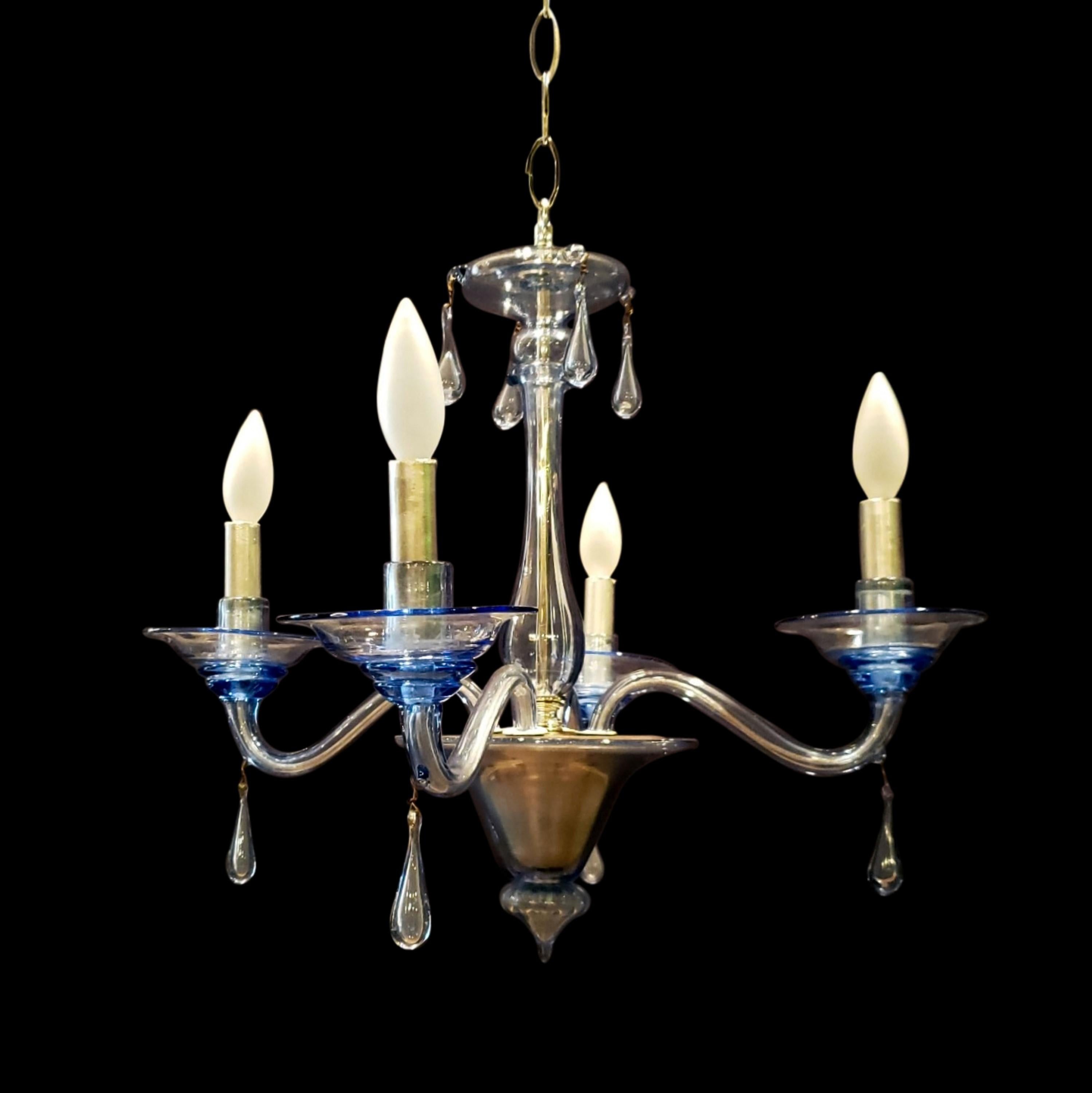 This Murano glass chandelier features a light blue hue and has four arms. This comes rewired and ready to install. Ships disassembled. Cleaned and restored. Please note, this item is located in our Scranton, PA location.