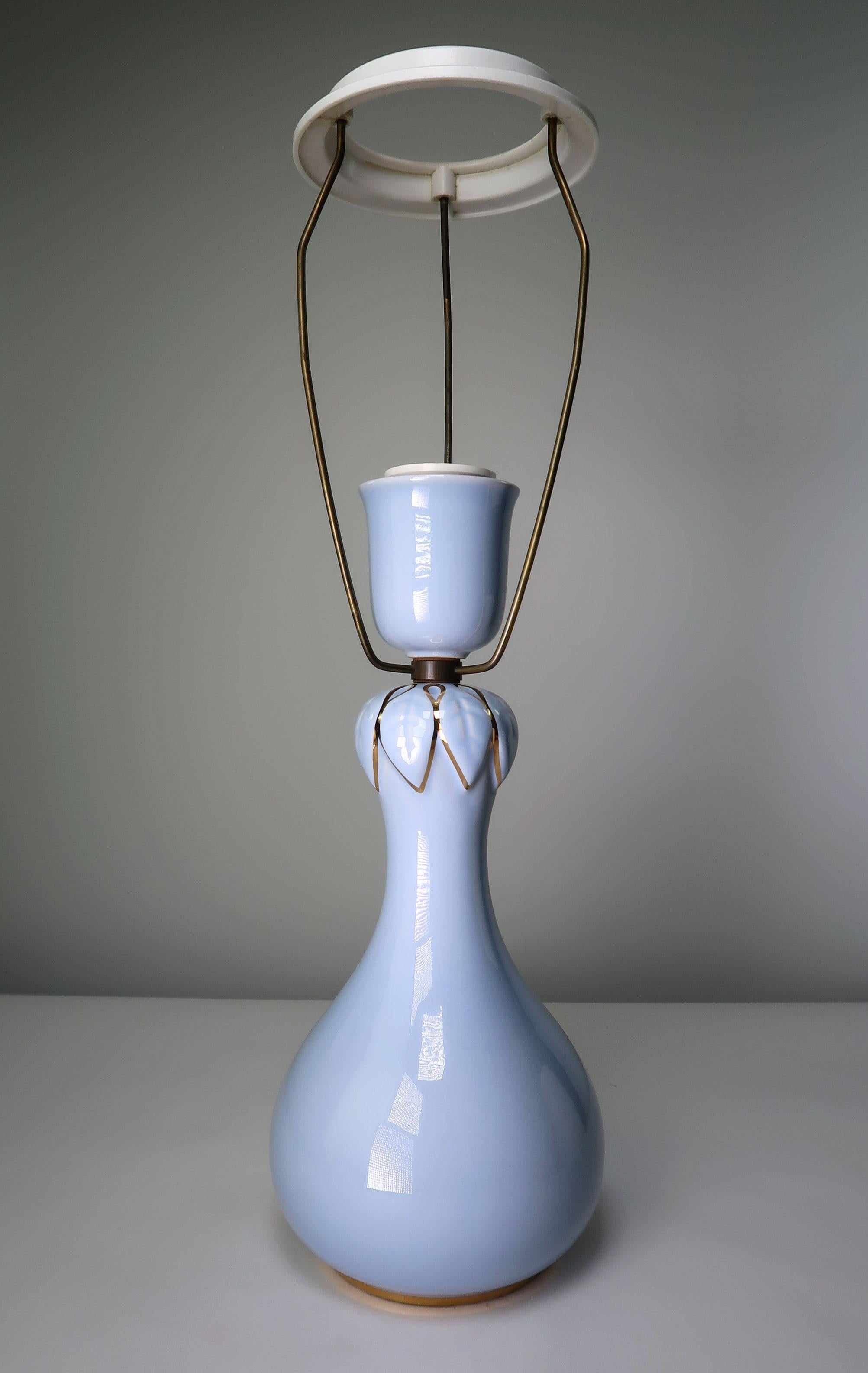 Lovely slender Danish Mid-Century Modern hour glass shaped light blue table lamp with golden decor on top and bottom. Leaf shaped relief pattern around the neck of the lamp accentuated with golden decorations. Manufactured on the island of Bornholm