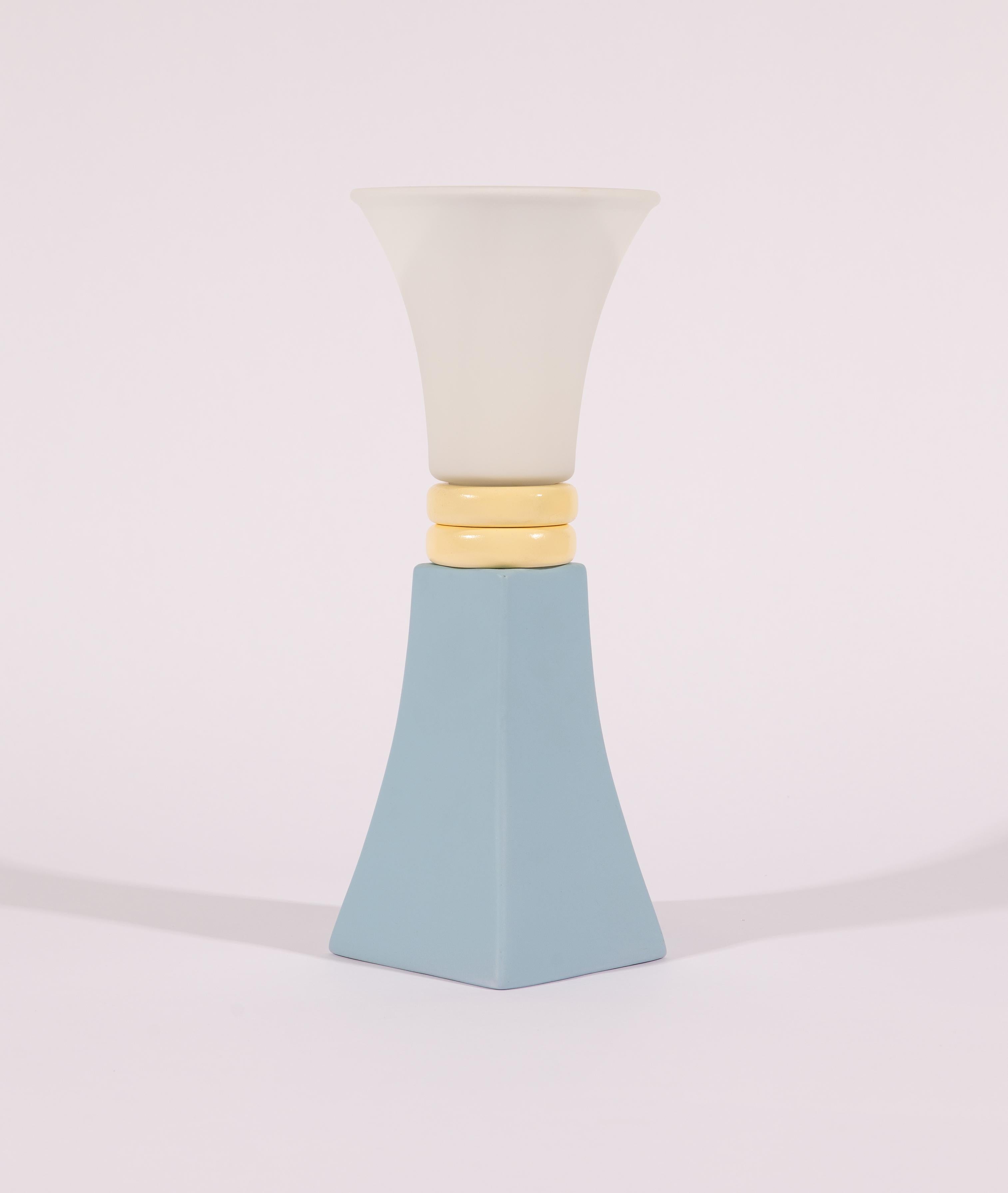 The “Pale Morning/ 7am” lamp is a handcrafted, one-of-a-kind piece made from the white vintage glass shade, light blue ceramic element, and painted wooden elements. Its pastel color palette, soft light from a 15W iridescent bulb, and curved lines