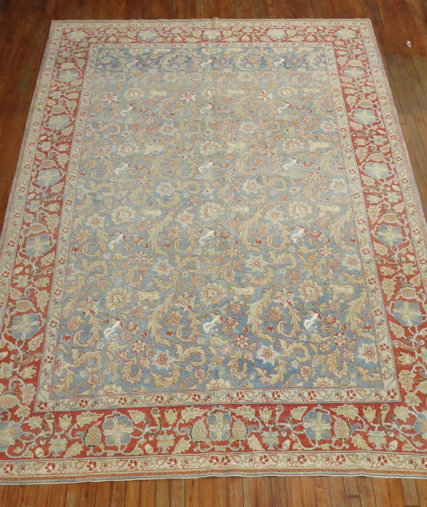 early 20th century Persian Tabriz Pictorial rug in predominant light blue featuring a flurry of small animals floating in field and border. 

Measures: 7'4