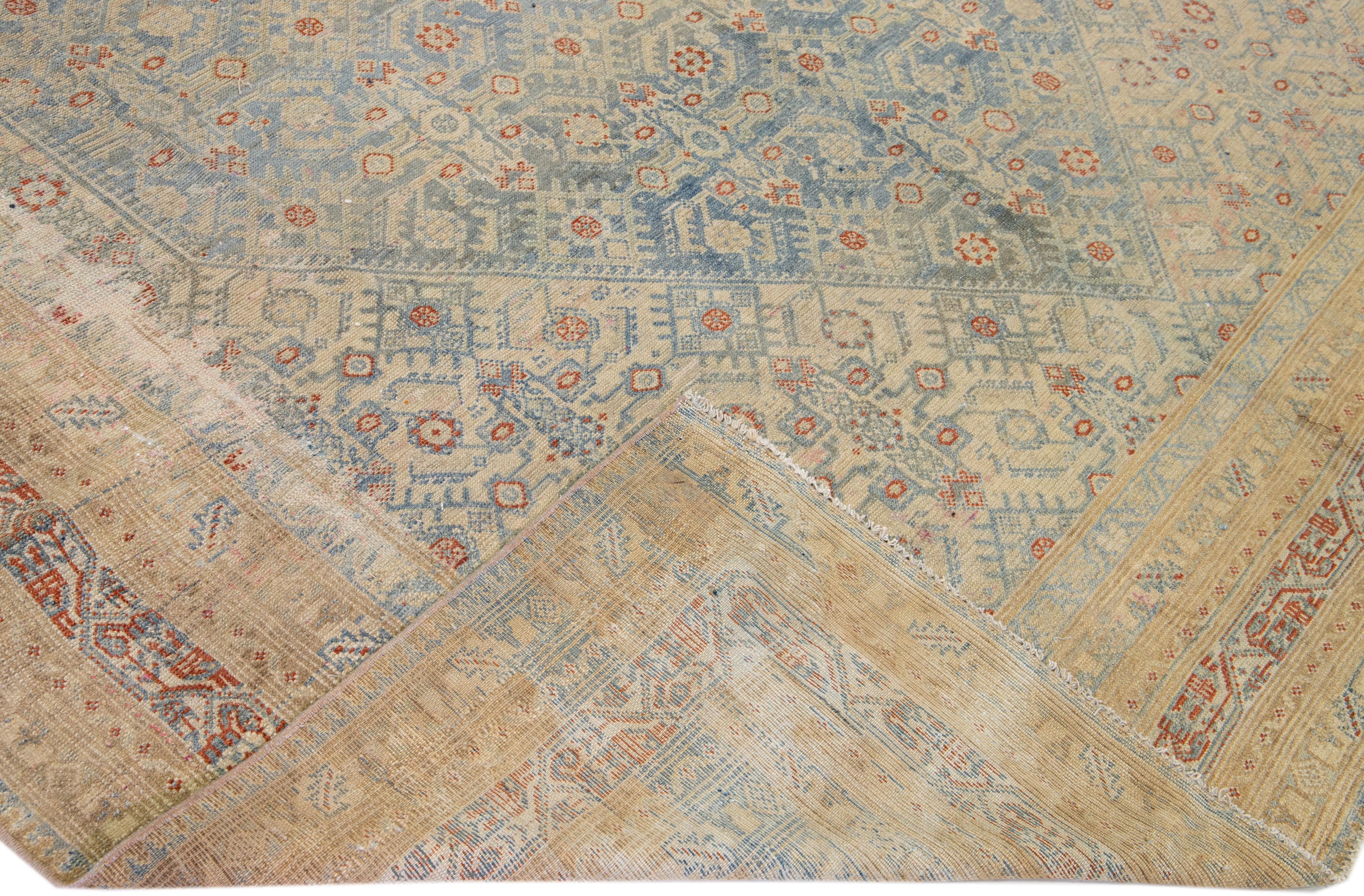 Beautiful antique Malayer hand-knotted wool rug with a light blue color field. This Persian piece has a frame with rust and tan accents in a gorgeous all-over geometric medallion design.

This rug measures: 8'6