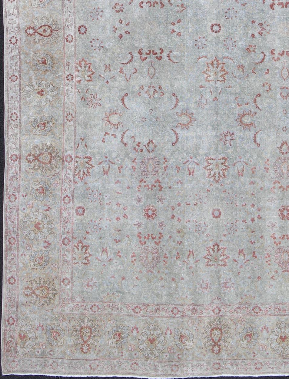 Light blue antique Persian Tabriz rug with floral design and hints of red, rug dan-g77, country of origin / type: Iran / Tabriz, circa 1920

This antique Persian Tabriz carpet, circa early 20th century, features both muted and faded colors and an