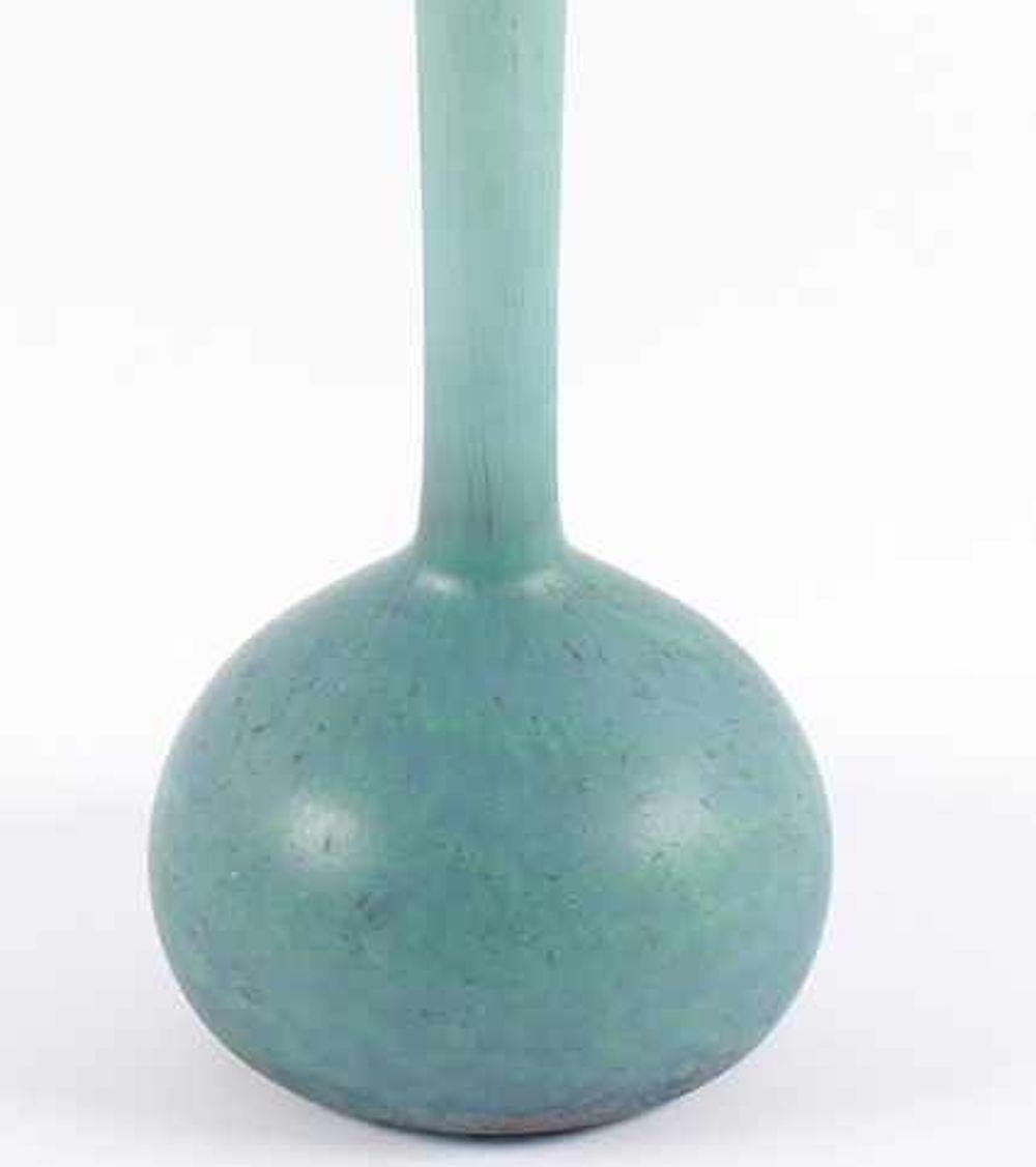 Diese hellblaue Berluze-Vase ist ein originelles Dekorationsobjekt, das in den 1920er Jahren von André Delatte entworfen wurde.

Diese schöne farbige Glasvase heißt Berluze (Langhalsvase in persischer Form) und wurde von André Delatte hergestellt,