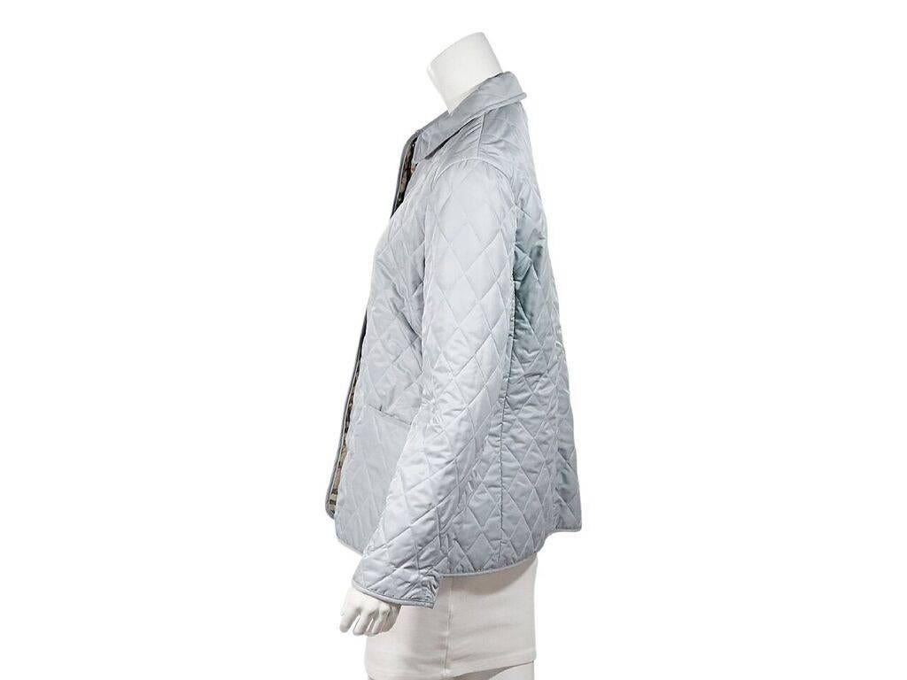 Product details:  Light blue quilted lightweight jacket by Burberry London.  Spread collar.  Long sleeves.  Snap-front closure.  Waist slide pockets.  38