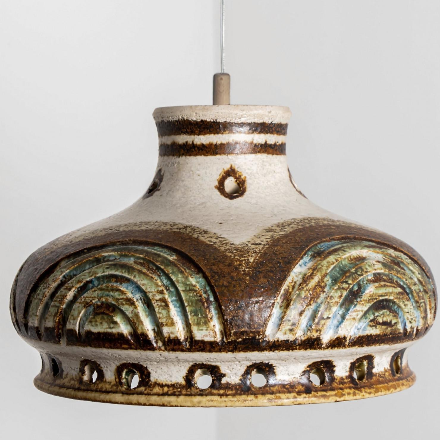 Stunning round hanging lamp with an unusual shape, made with rich colored light blue ceramics, manufactured in the 1970s in Denmark. We also have a multitude of unique colored ceramic light sets and arrangements, all available on the frontstore.