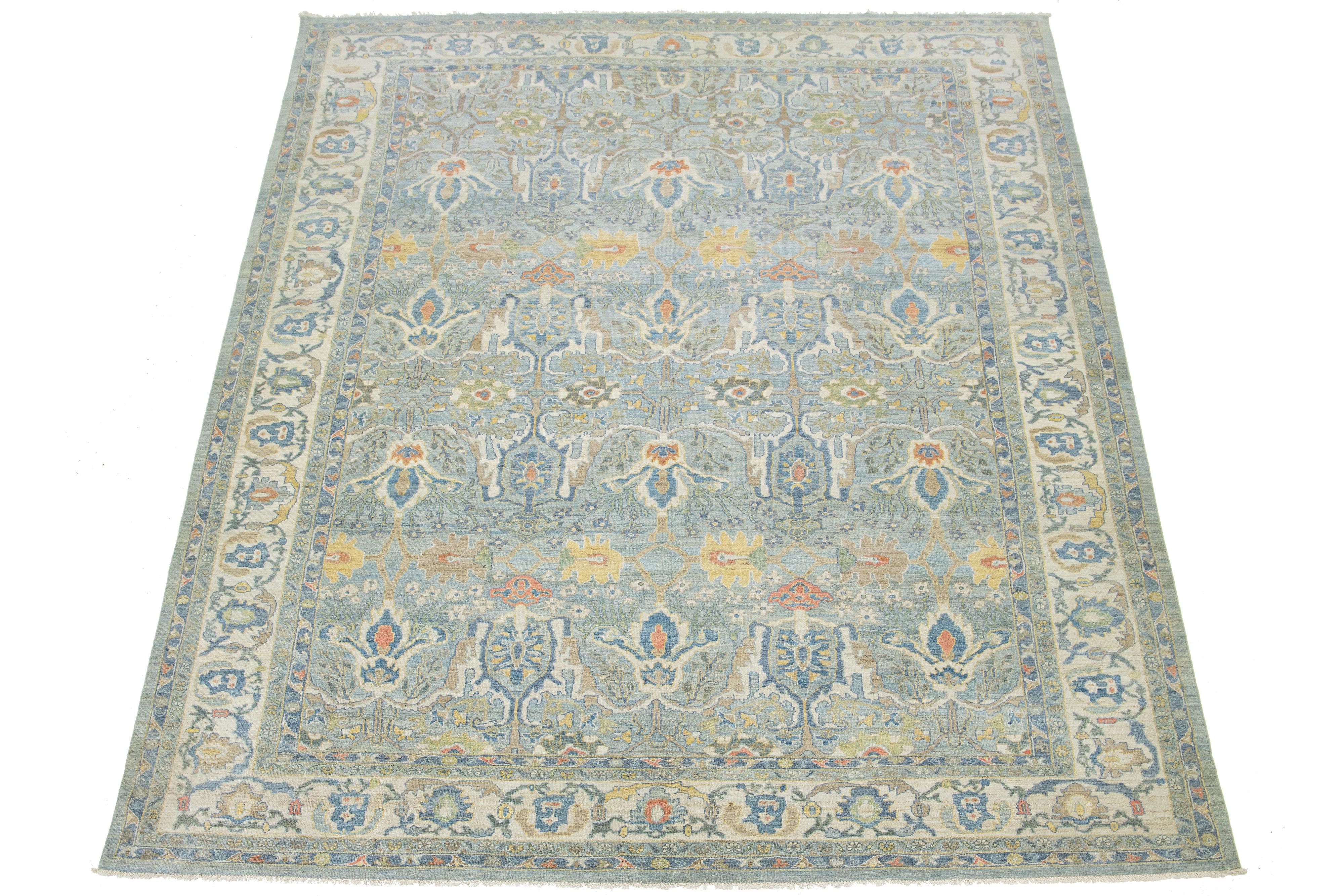 Verwandeln Sie Ihren Raum mit diesem auffälligen, handgeknüpften, übergroßen Sultanabad-Wollteppich, der einen ruhigen, hellblauen Hintergrund und kühne, mehrfarbige Muster aufweist. Es ist ein kraftvolles Statement von Kunstfertigkeit und