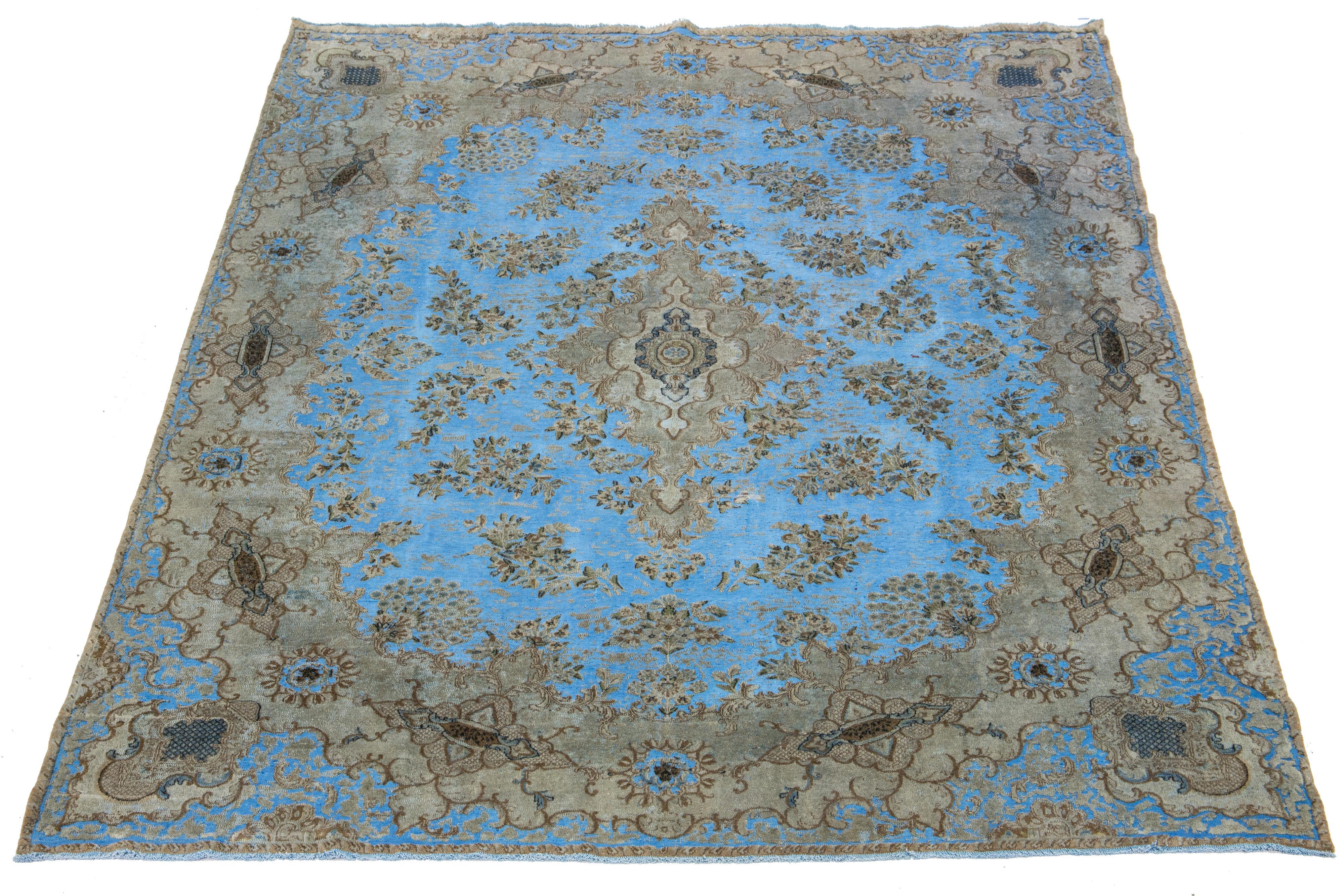 This antique Persian wool rug features a medallion floral design in light blue with beige and brown accents, all hand-knotted to perfection.

This rug measures 8'9'' x 12'3