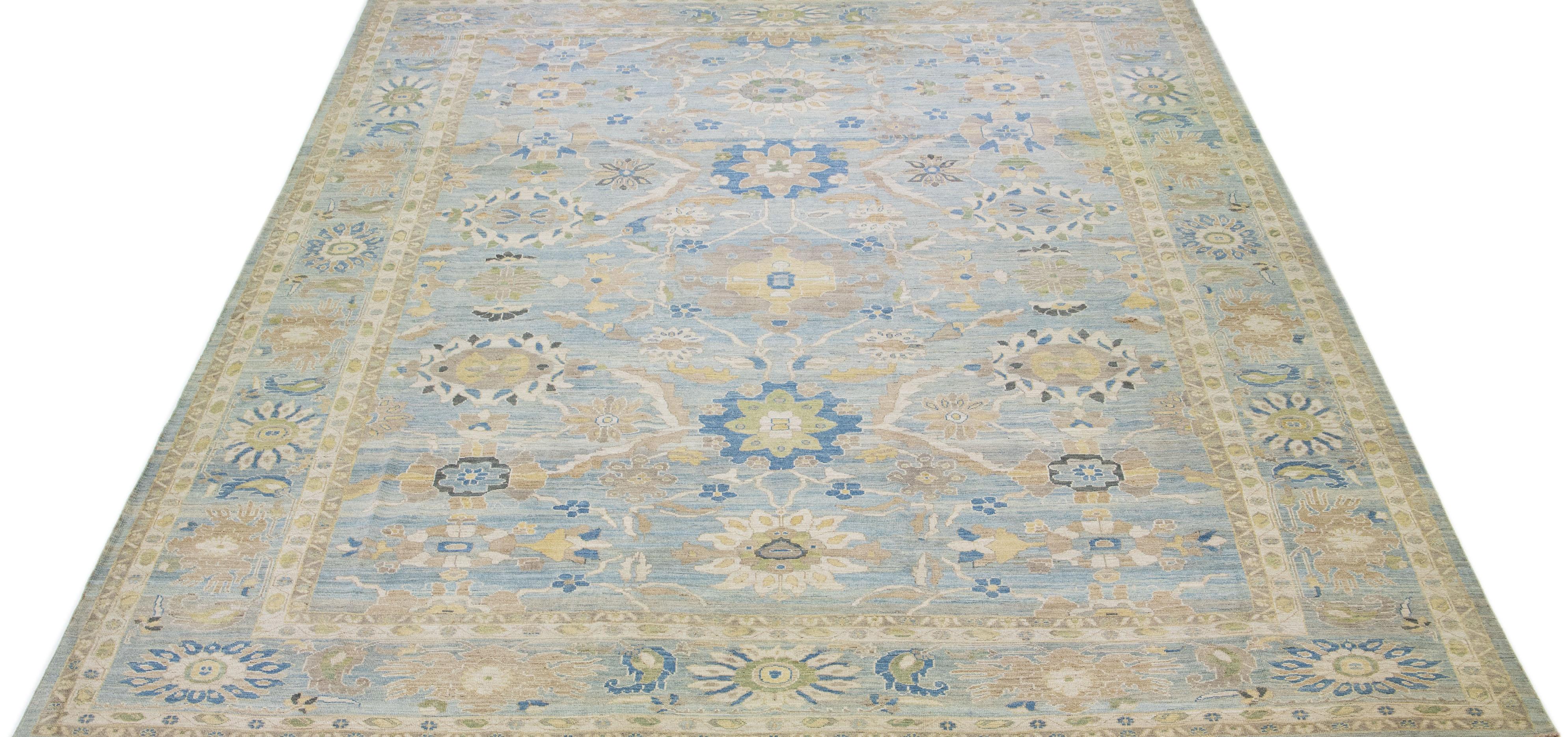 Beautiful modern Sultanabad hand knotted wool rug with a light blue color field. This rug has a designed frame with beige, green, and brown accents in a gorgeous all-over floral design.

This rug measures: 14'10