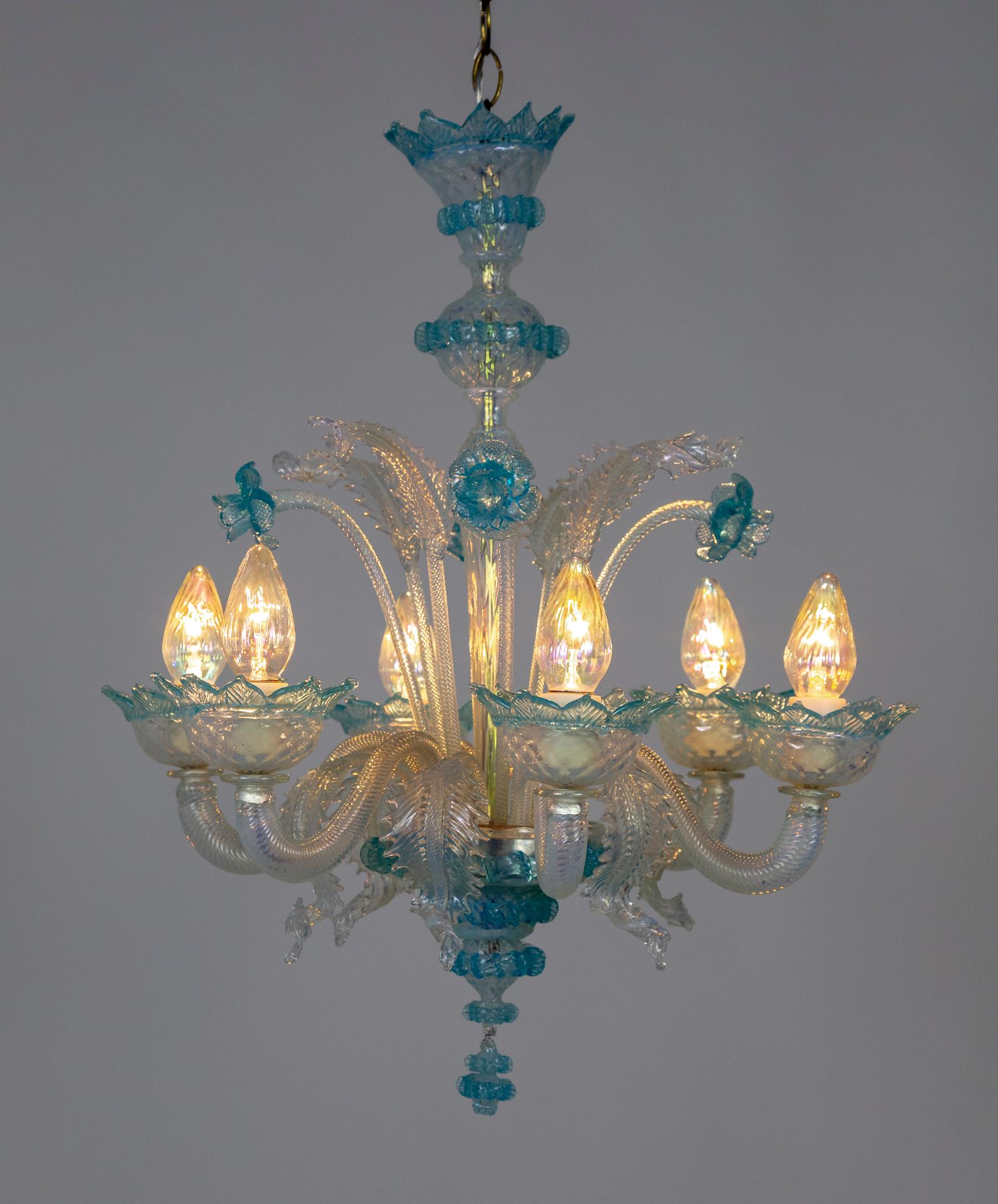A dazzling 1950s Murano glass chandelier in iridescent white and light blue; embellished with sprouting daffodils and 2 sizes of shimmering leaves. The 6 arms have a twisted, ribbed texture and the body and flowers knit-molded. Attributed to