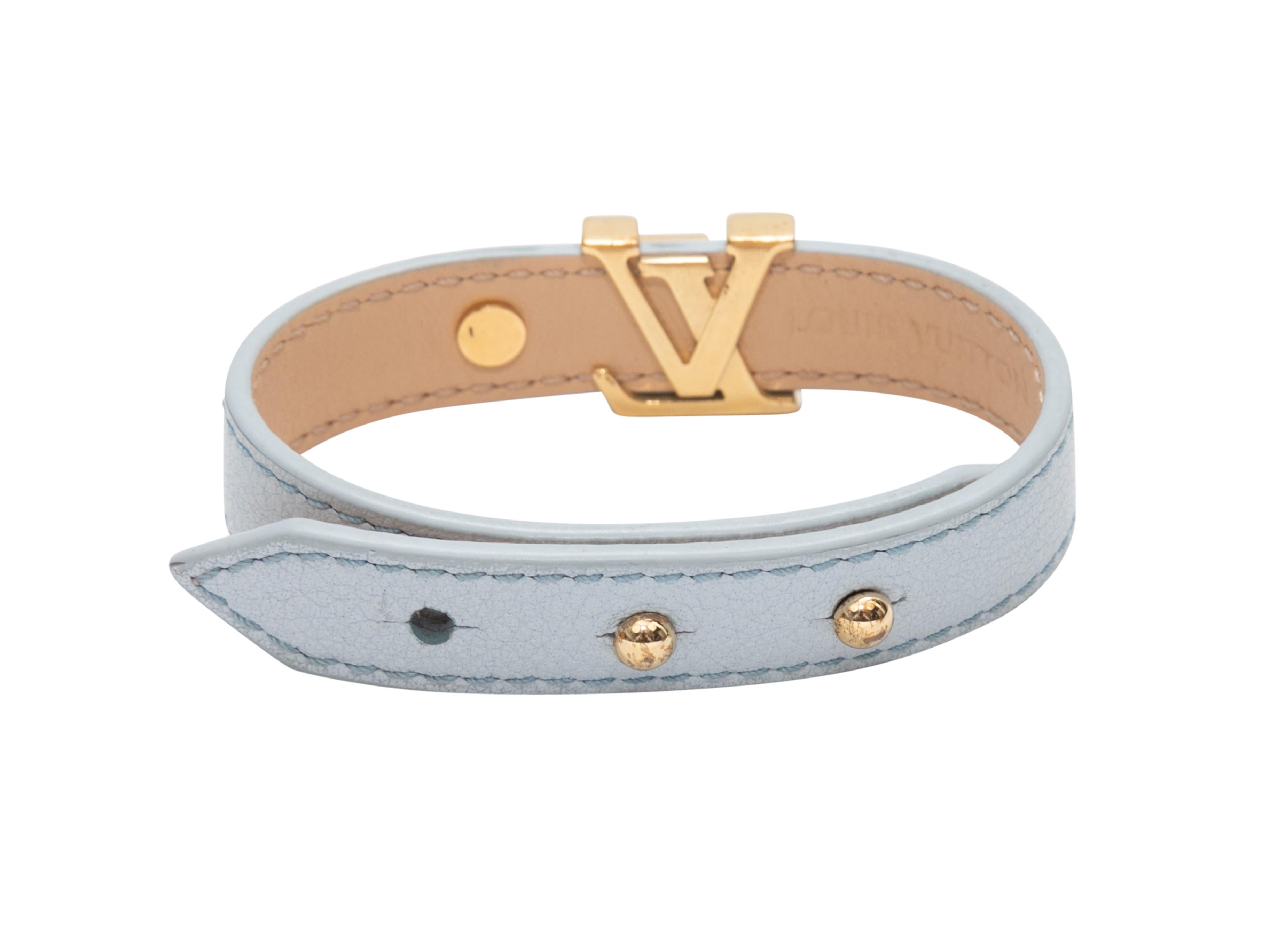Light blue leather logo bracelet by Louis Vuitton. Gold-tone hardware. Peg-in-hole closure. 0.5