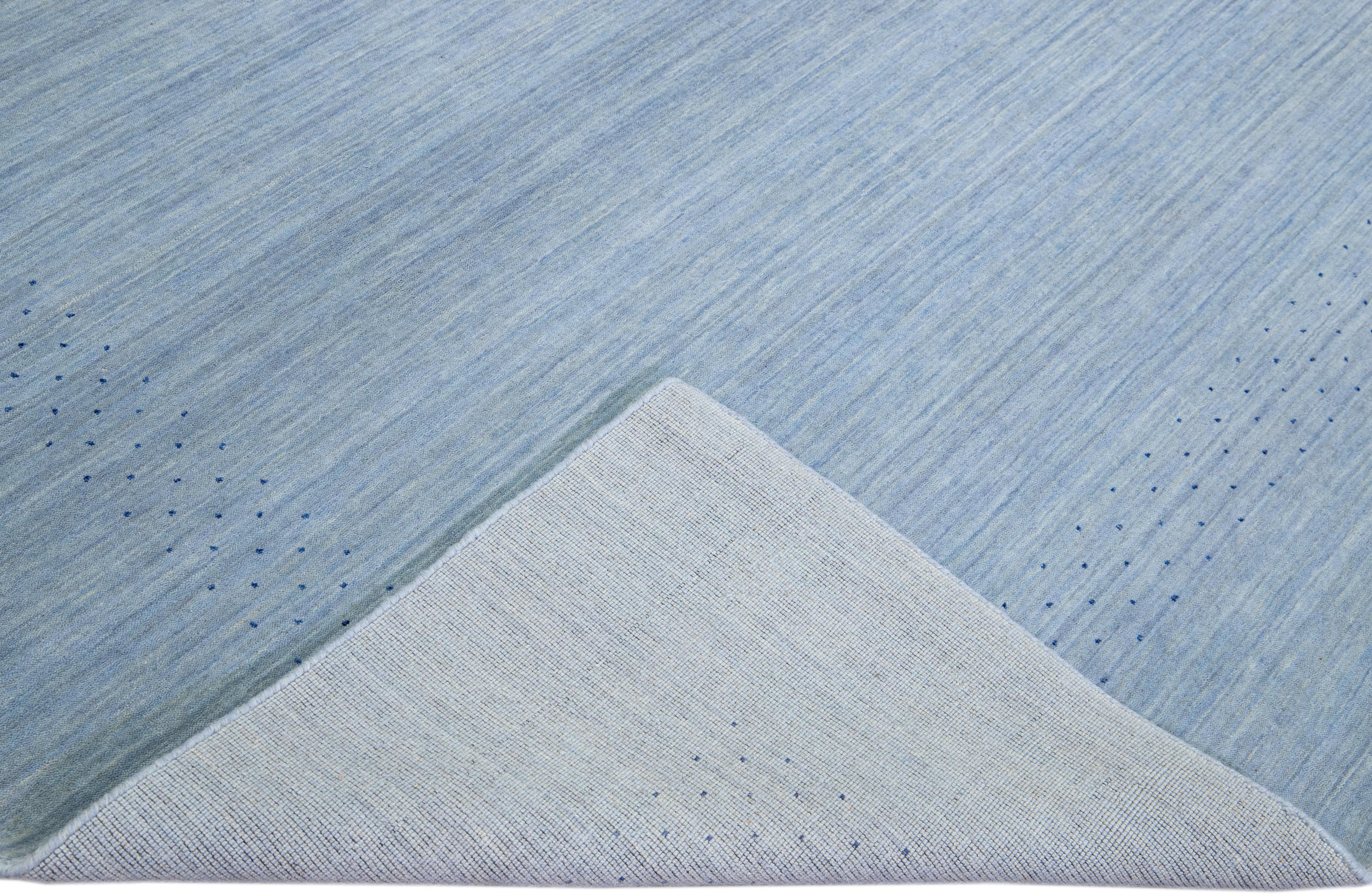 Beautiful modern Gabbeh style hand-Loom wool rug with a light blue field. This Gabbeh-style rug has gray accents in a gorgeous all-over geometric minimal design.

This rug measures: 9'2