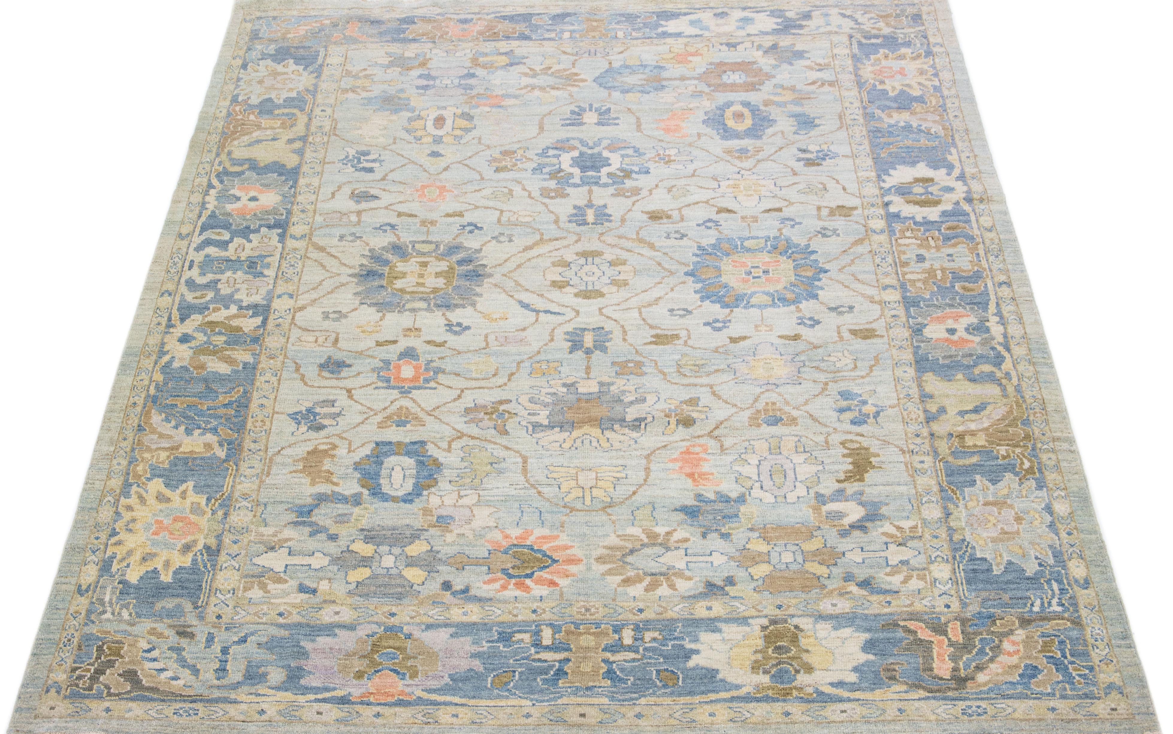 Beautiful modern Sultanabad hand knotted wool rug with a light blue color field. This rug has a navy blue-designed frame with peach, tan, and brown accents in a gorgeous all-over floral motif.

This rug measures: 9'6