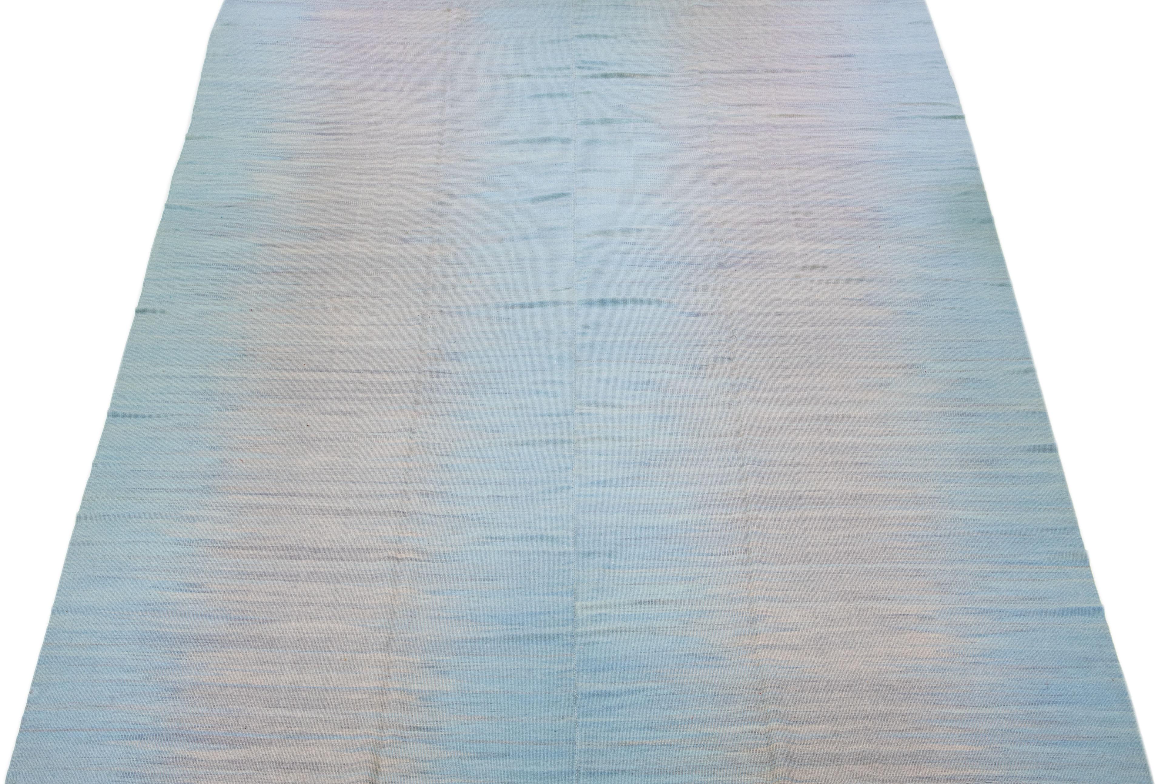 Beautiful Contemporary Kilim flatweave wool rug with a light blue color field. This Turkish rug features a gorgeous abstract design in beige. 

This rug measures: 12' x 16'5
