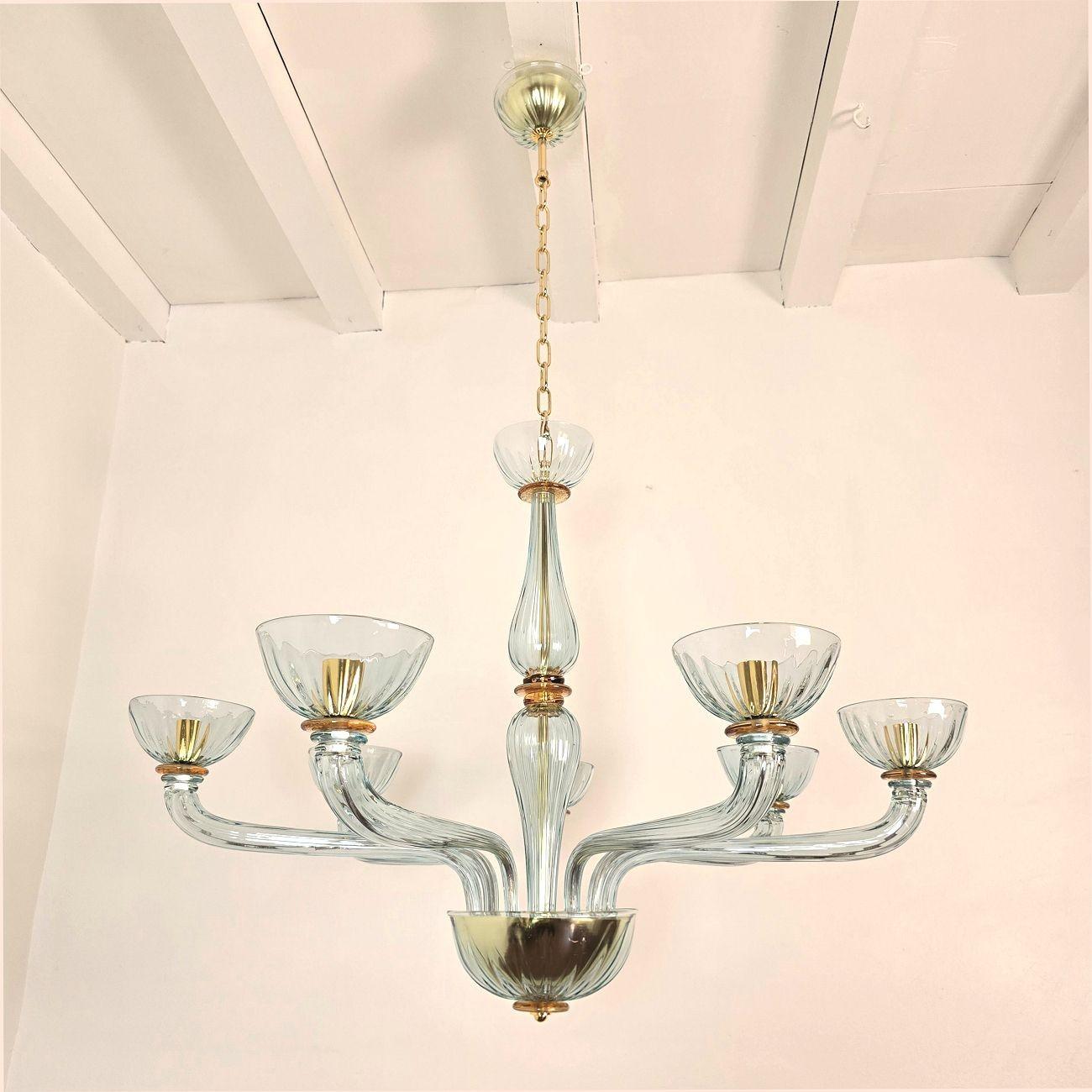 Light blue Mid Century Modern Murano glass chandelier, Barovier and Toso style, Italy 1980s.
The handmade Murano glass chandelier is made of a light blue - aqua blue color, with amber - caramel accents.
The Italian chandelier has 7 lights and is