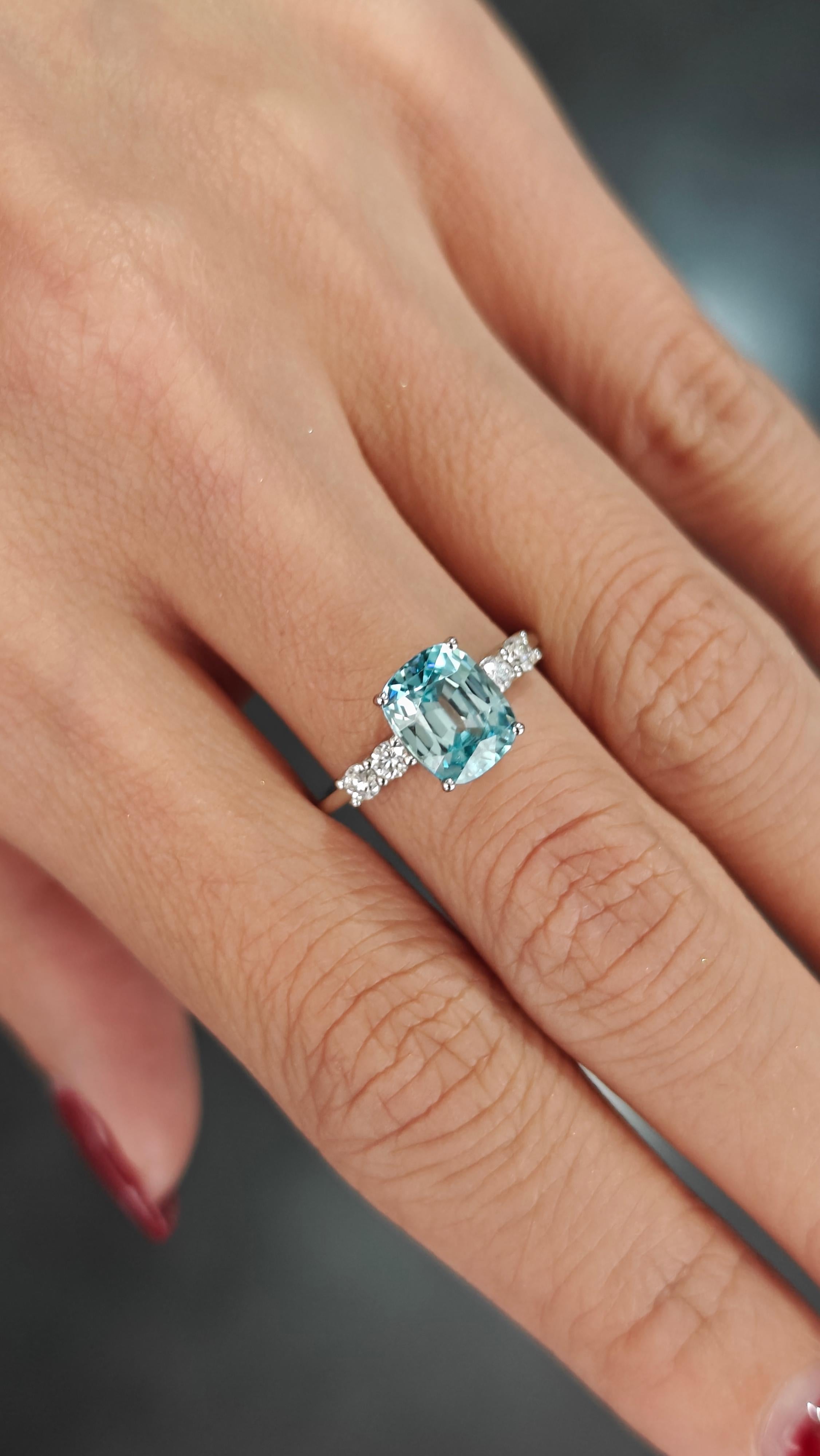 Dieser bezaubernde Platinring ist mit einem natürlichen blauen Zirkon im Kissenschliff verziert, der mit seinem eisblauen Farbton an das ruhige Wasser des Ozeans erinnert. Der lebhafte Edelstein ist sorgfältig in einer eleganten Vier-Zacken-Fassung