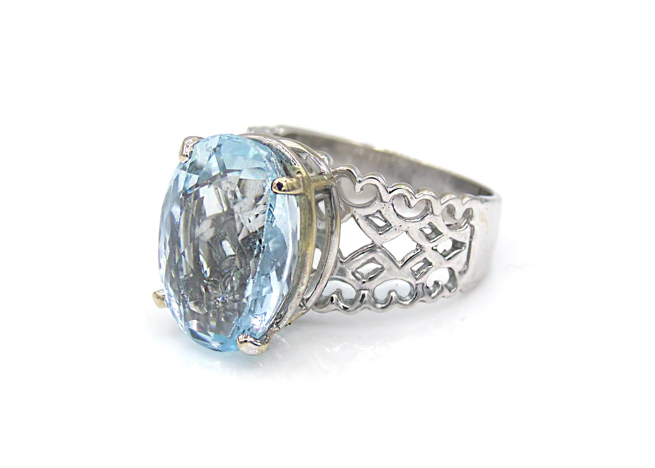 This stylish ring features a beautiful oval-cut light Blue Topaz center stone, weighing in at 8 Carats total. The topaz is high set upon a one-of-a-kind 14K White Gold band that is made with open filigree work in the shape of modern hearts. 

8