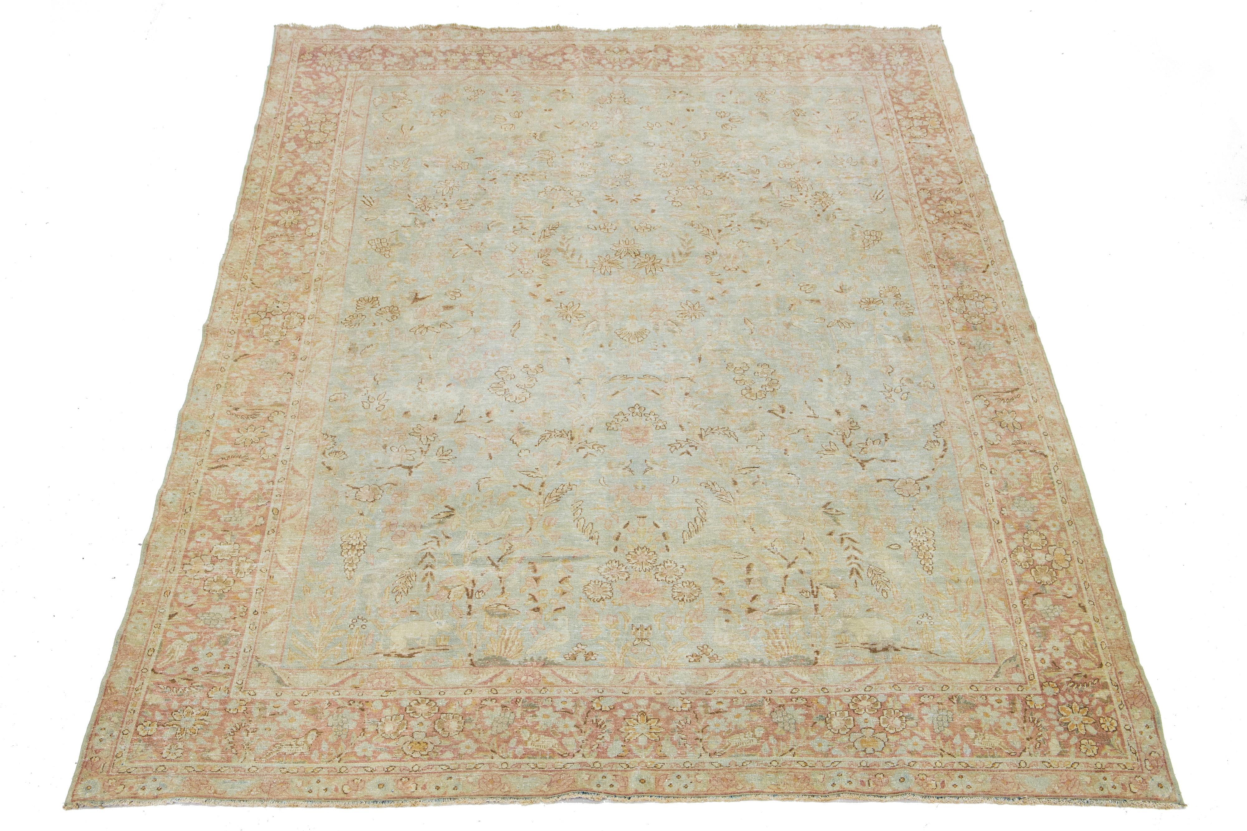 This hand-knotted wool rug from Malyer features a delightful antique finish. The rug has a light blue field embellished with an exquisite all-over floral pattern, accented by touches of deep brown and rust—showcasing the impressive craft of Persian
