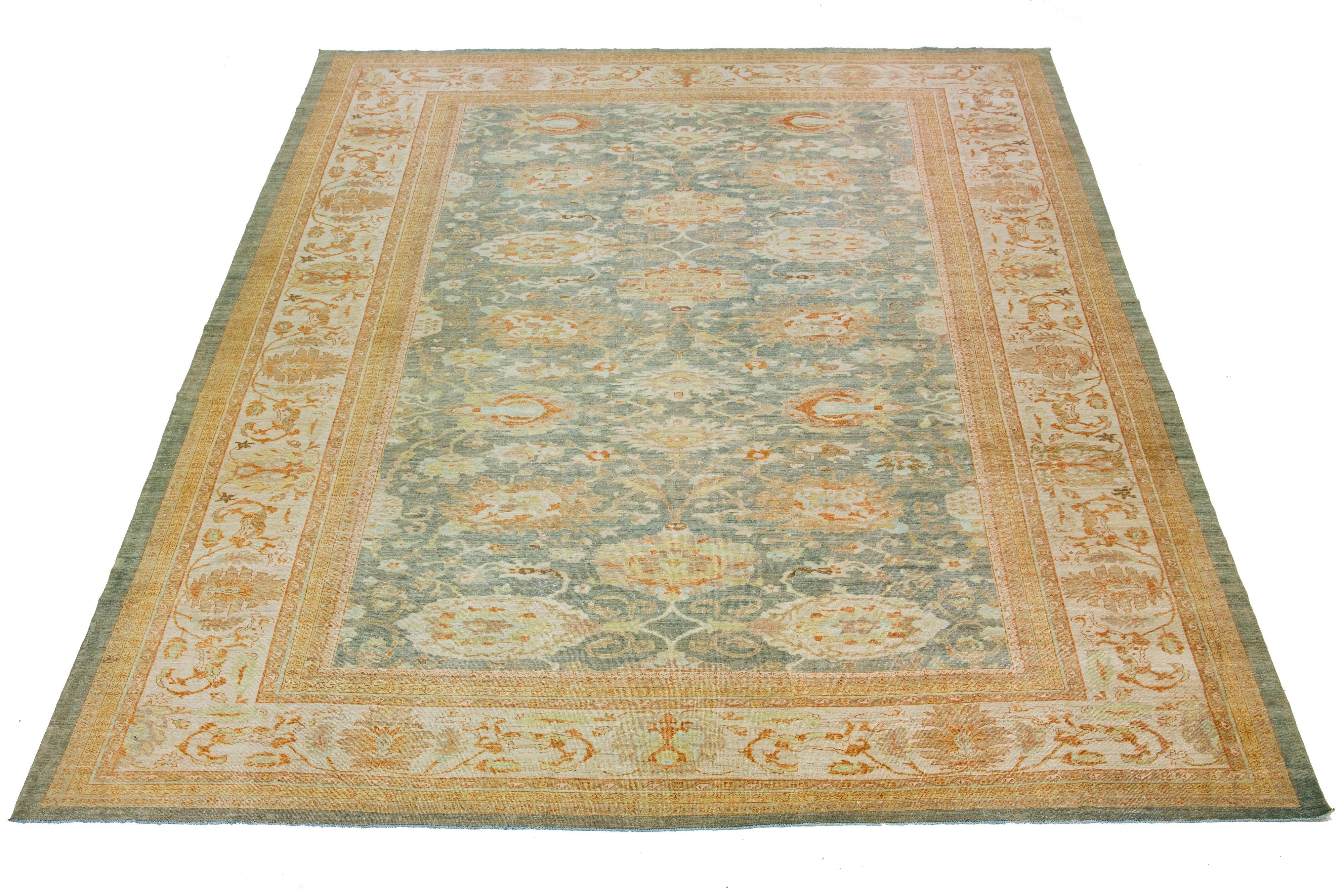 Beautiful antique Persian hand-knotted wool rug with a light blue color field. This piece has a beige frame with orange and green accents in a gorgeous all-over floral design.

This rug measures 13'8
