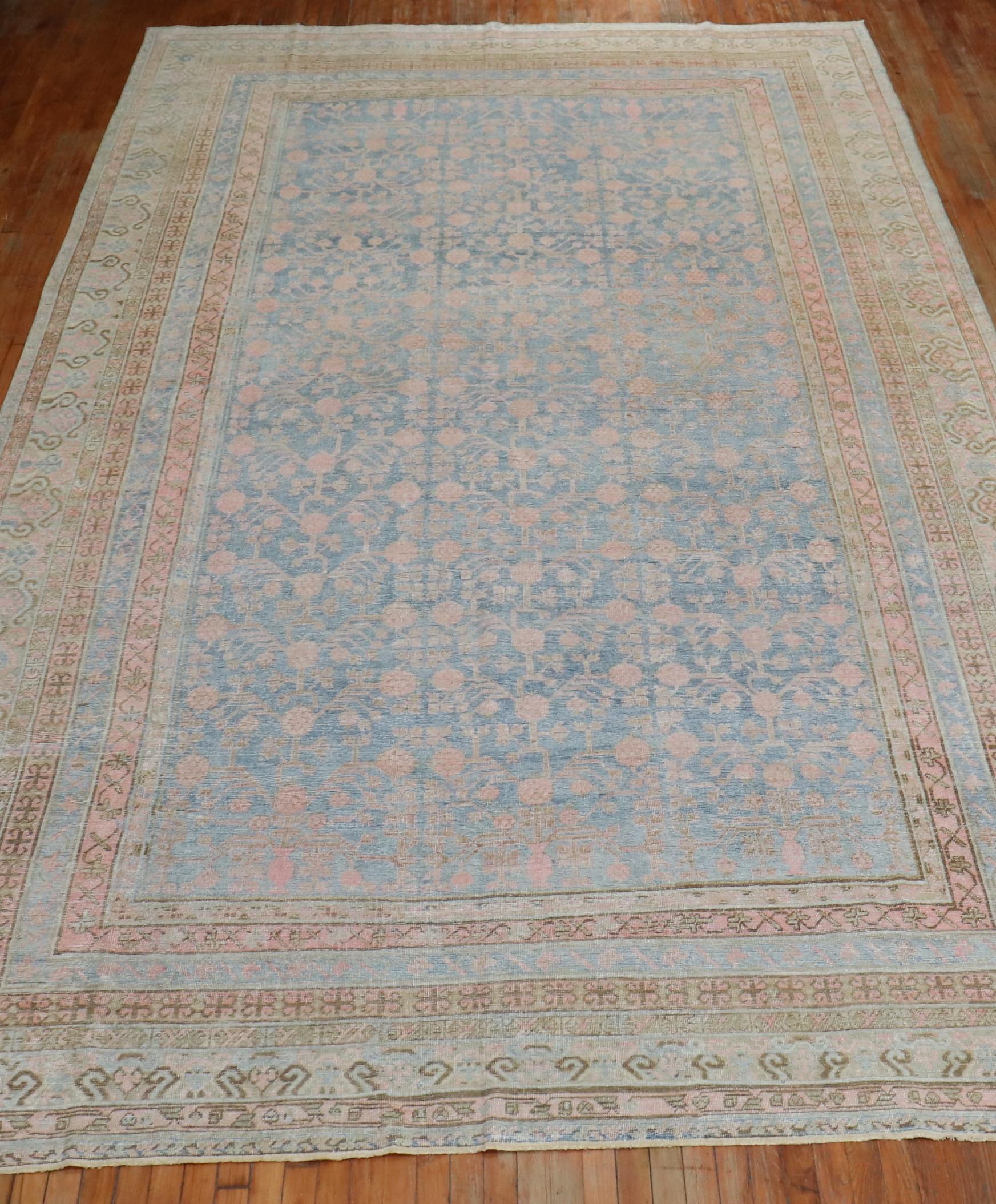 Grand tapis Khotan antique très décoratif de la région du Turkestan oriental, avec un champ bleu clair et des accents roses. Le motif de la grenade est tristement célèbre dans cette région,

vers 1910. Mesures : 9'2